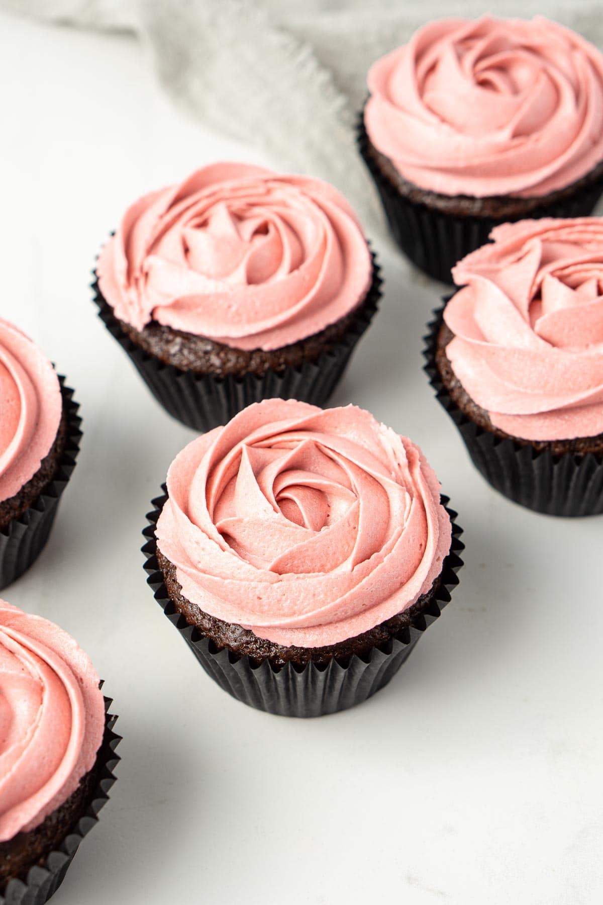 Close up of chocolate cupcakes with vegan vanilla buttercream roses piped on top.