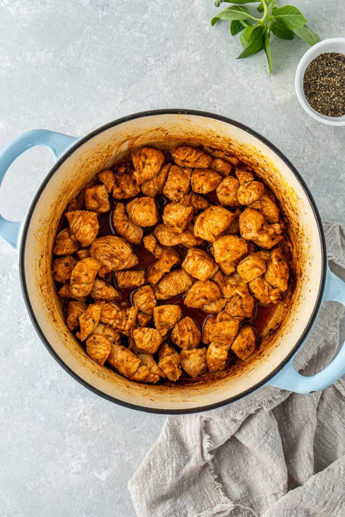 Cooking the chicken in the seasoning in the pot.