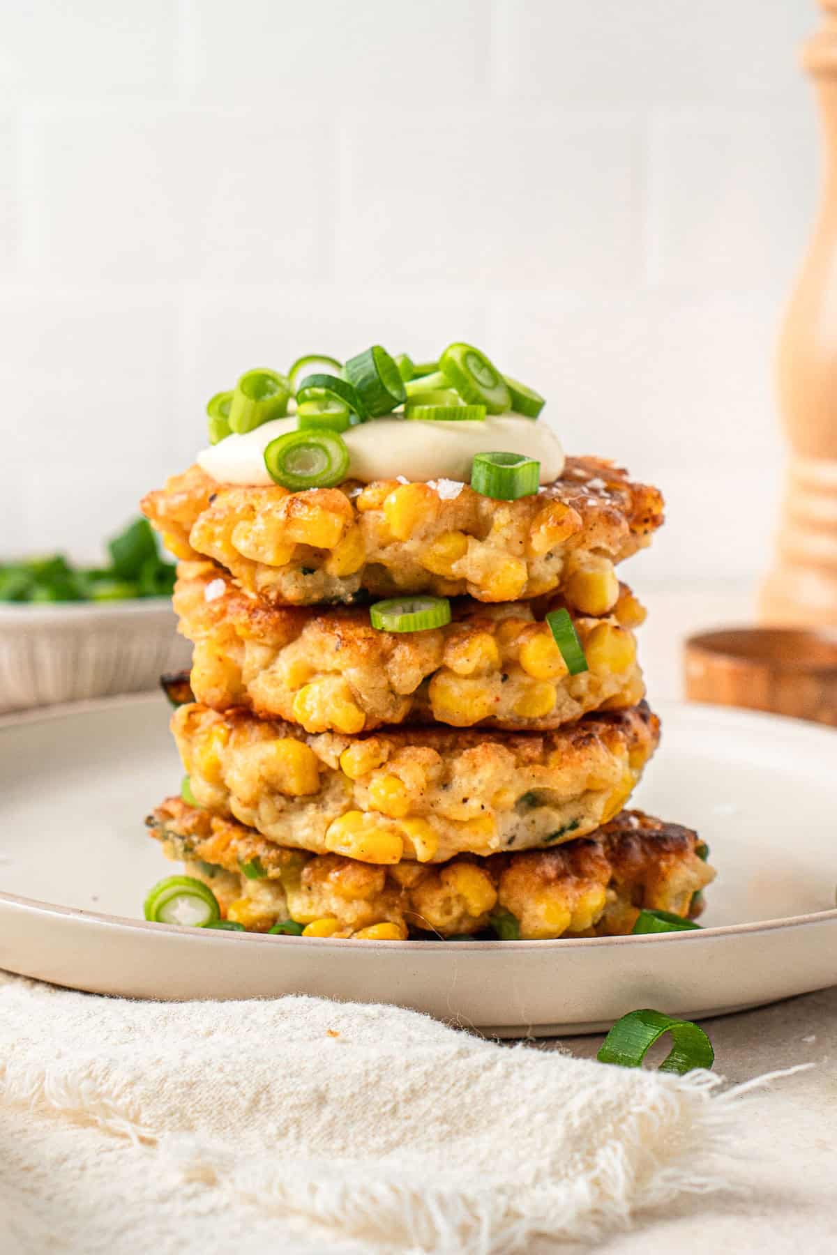 A stack of dairy free corn fritters served with mayo and spring onion.
