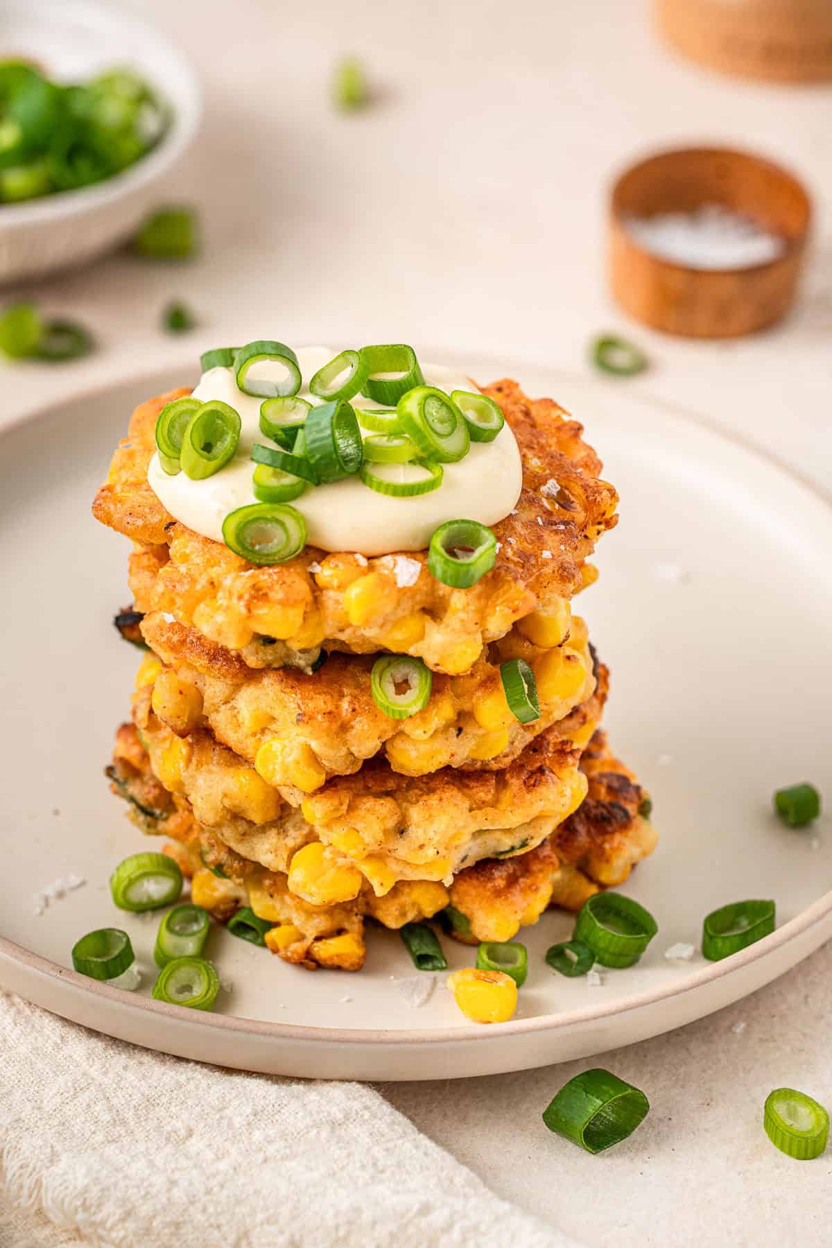 A stack of dairy free corn fritters served with mayo and spring onion.