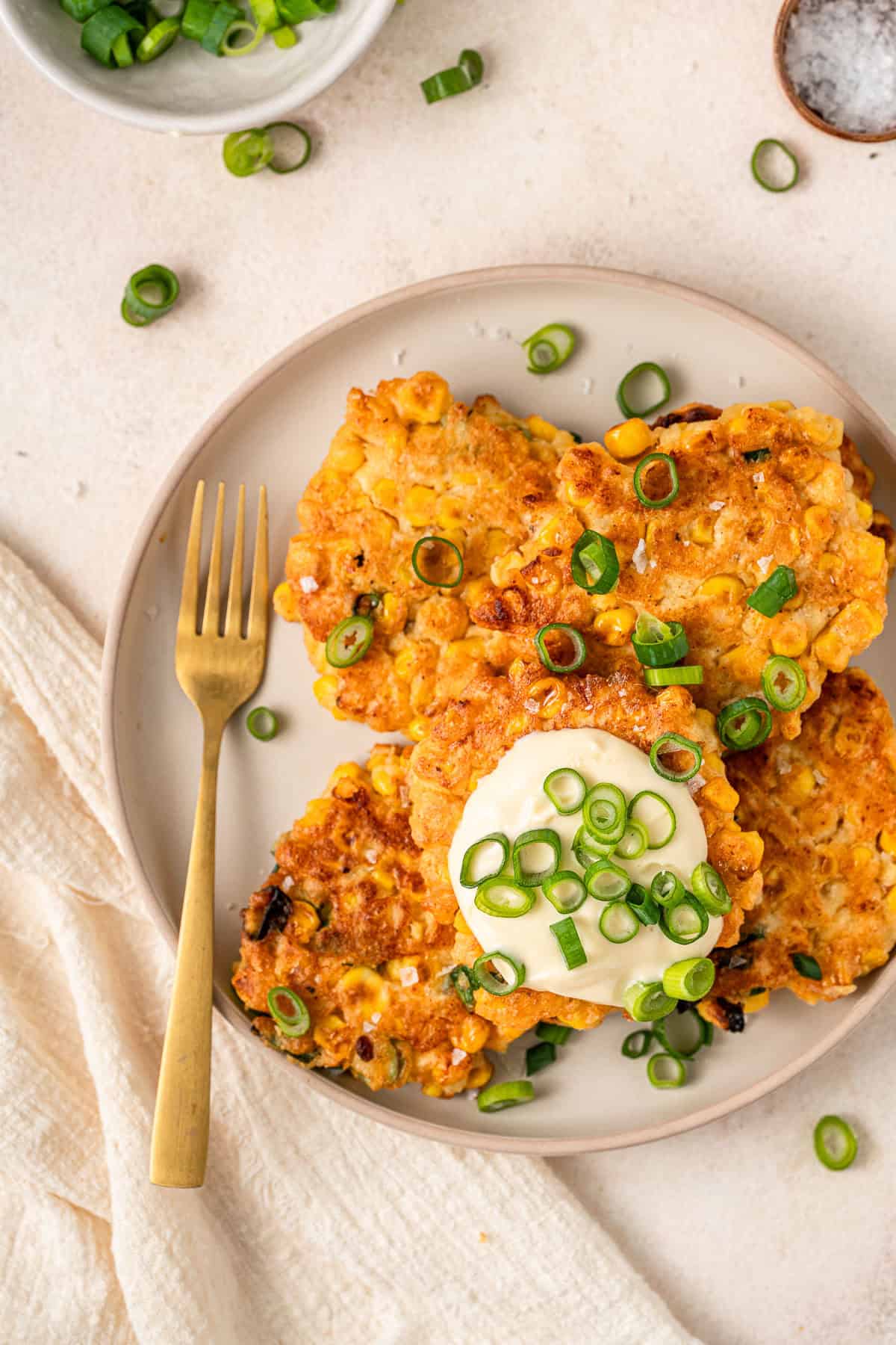 Gluten free corn fritters on a plate with a fork.