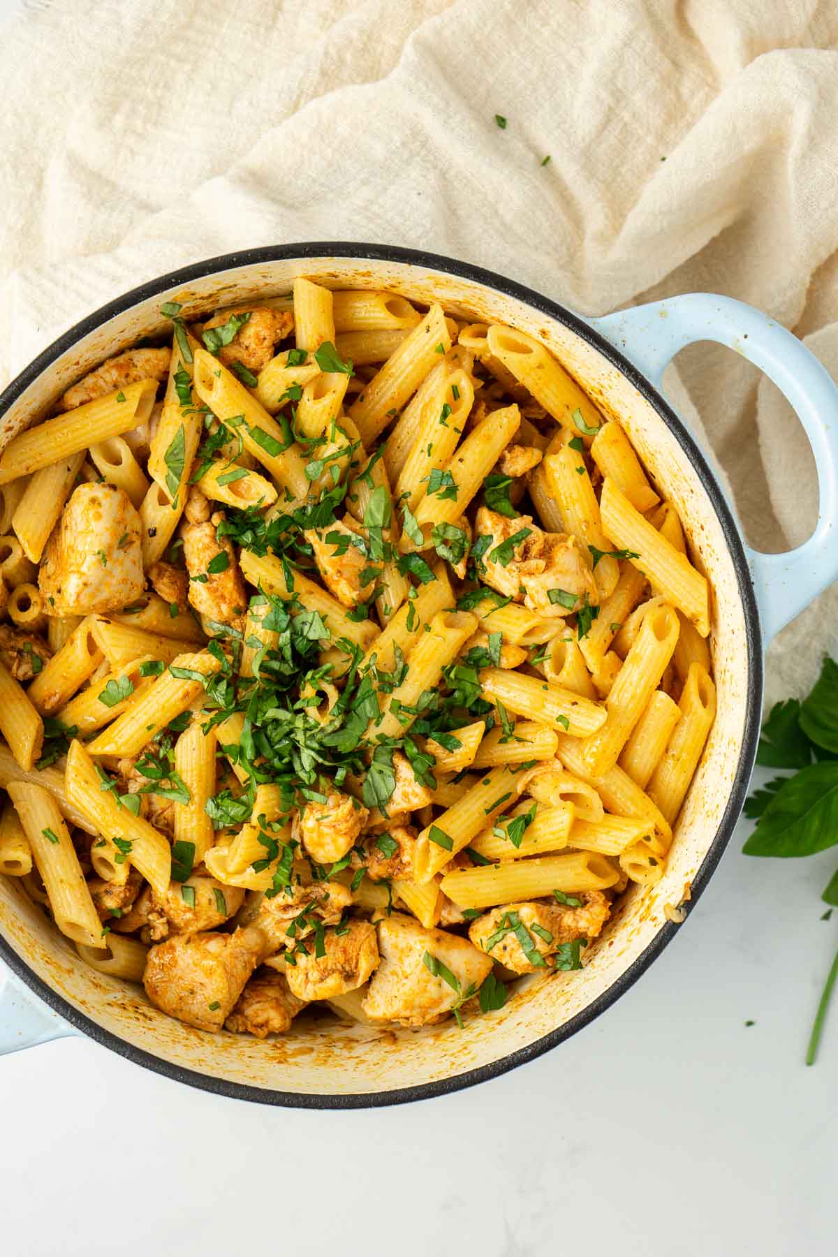 Large pot of creamy dairy free cajun chicken pasta topped with chopped fresh herbs.