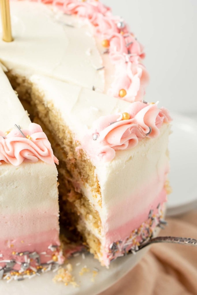 A slice being taken from a vegan vanilla cake.