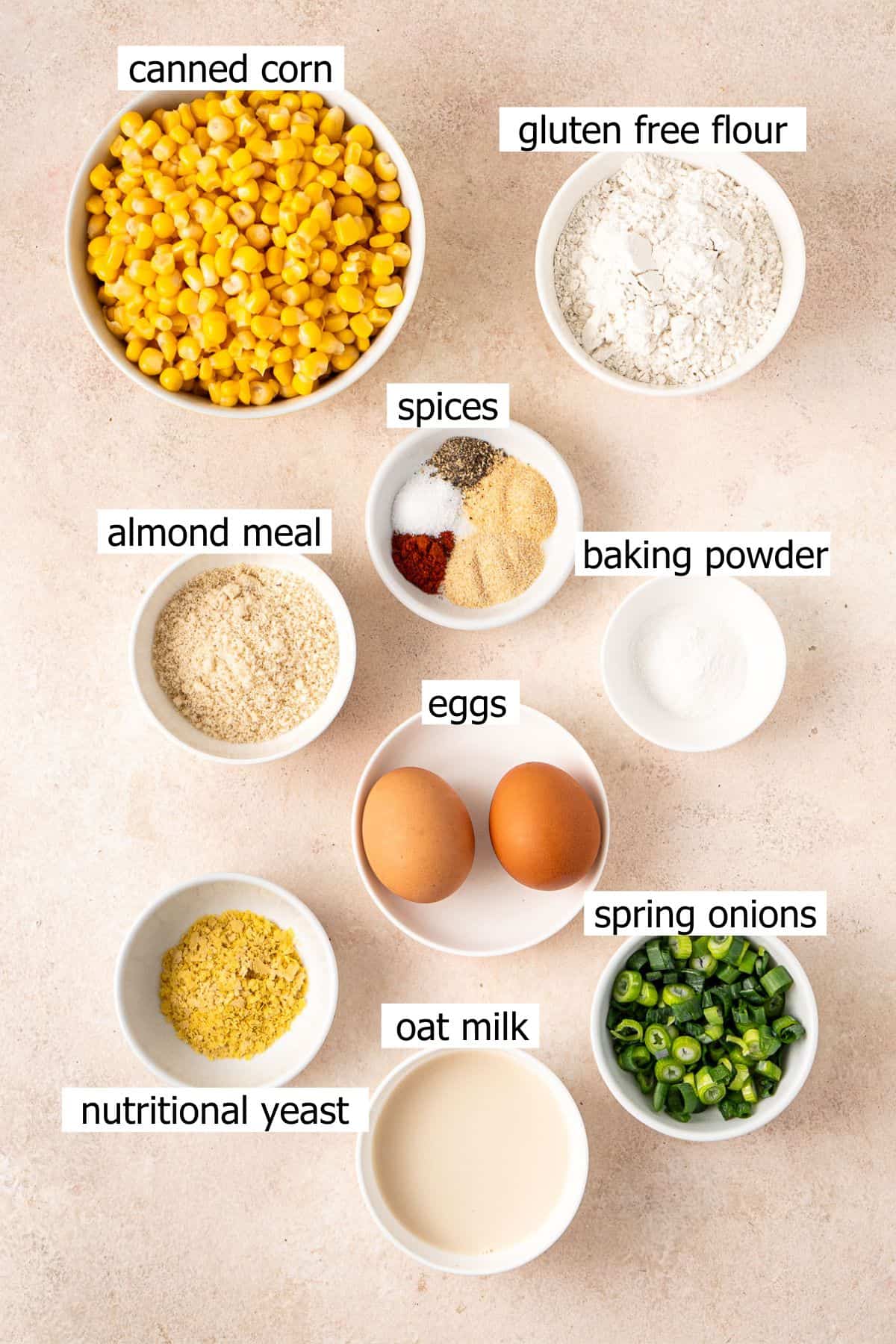 All ingredients needed to make gluten free corn fritters laid out in bowls.