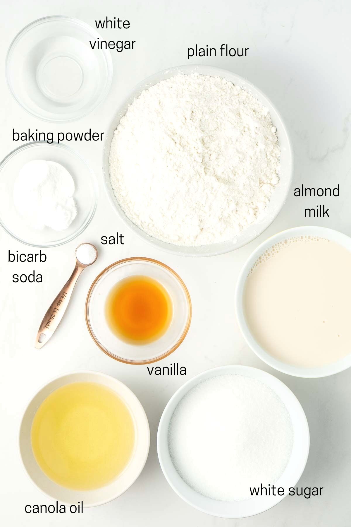 All ingredients needed to make the cake laid out in small bowls. 