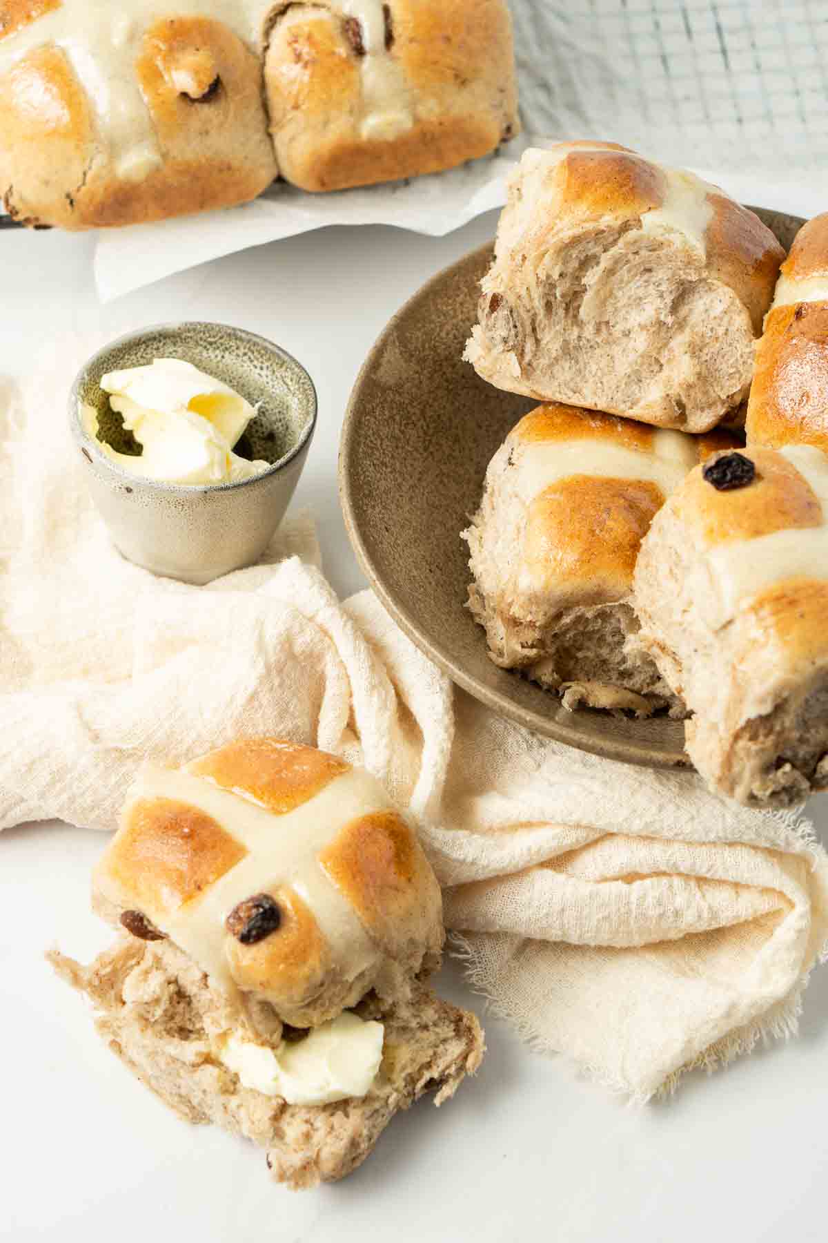 Freshly baked hot cross buns with butter.