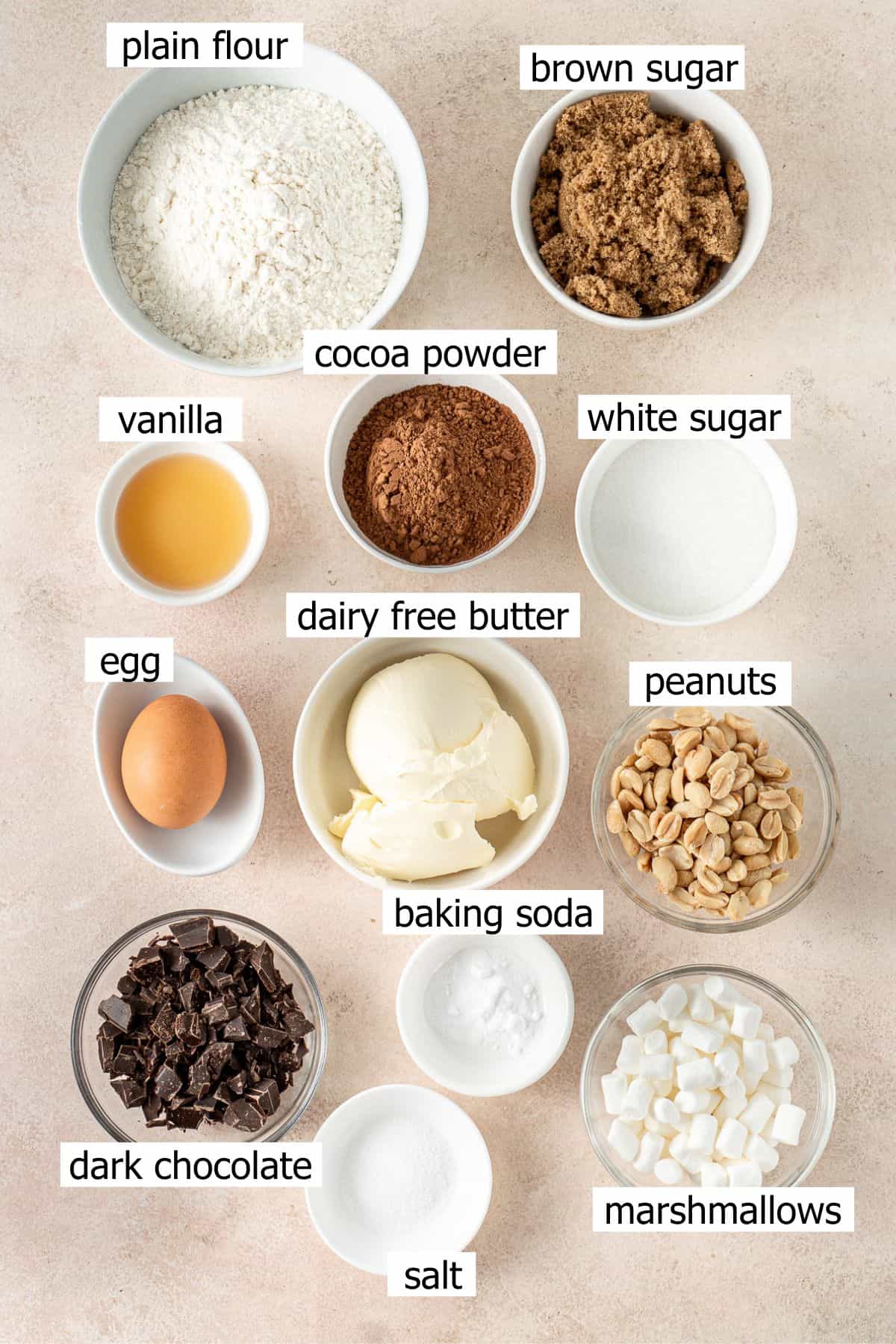 All ingredients needed to make rocky road cookies laid out in small bowls.