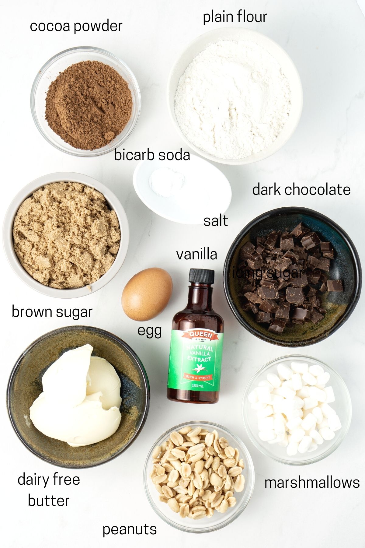 All ingredients needed to make rocky road cookies laid out in small bowls.