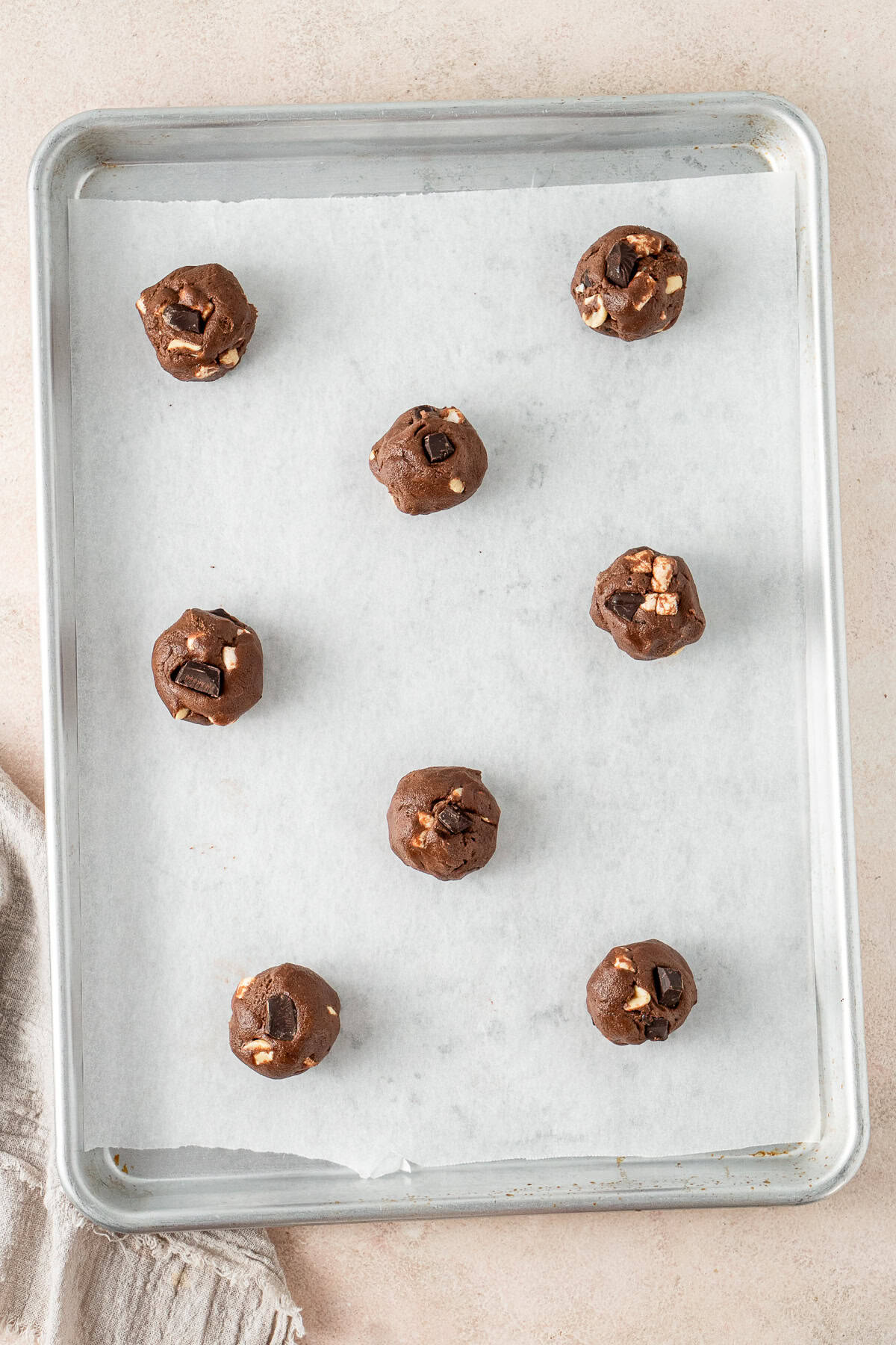 The balls of cookie dough on a baking tray.