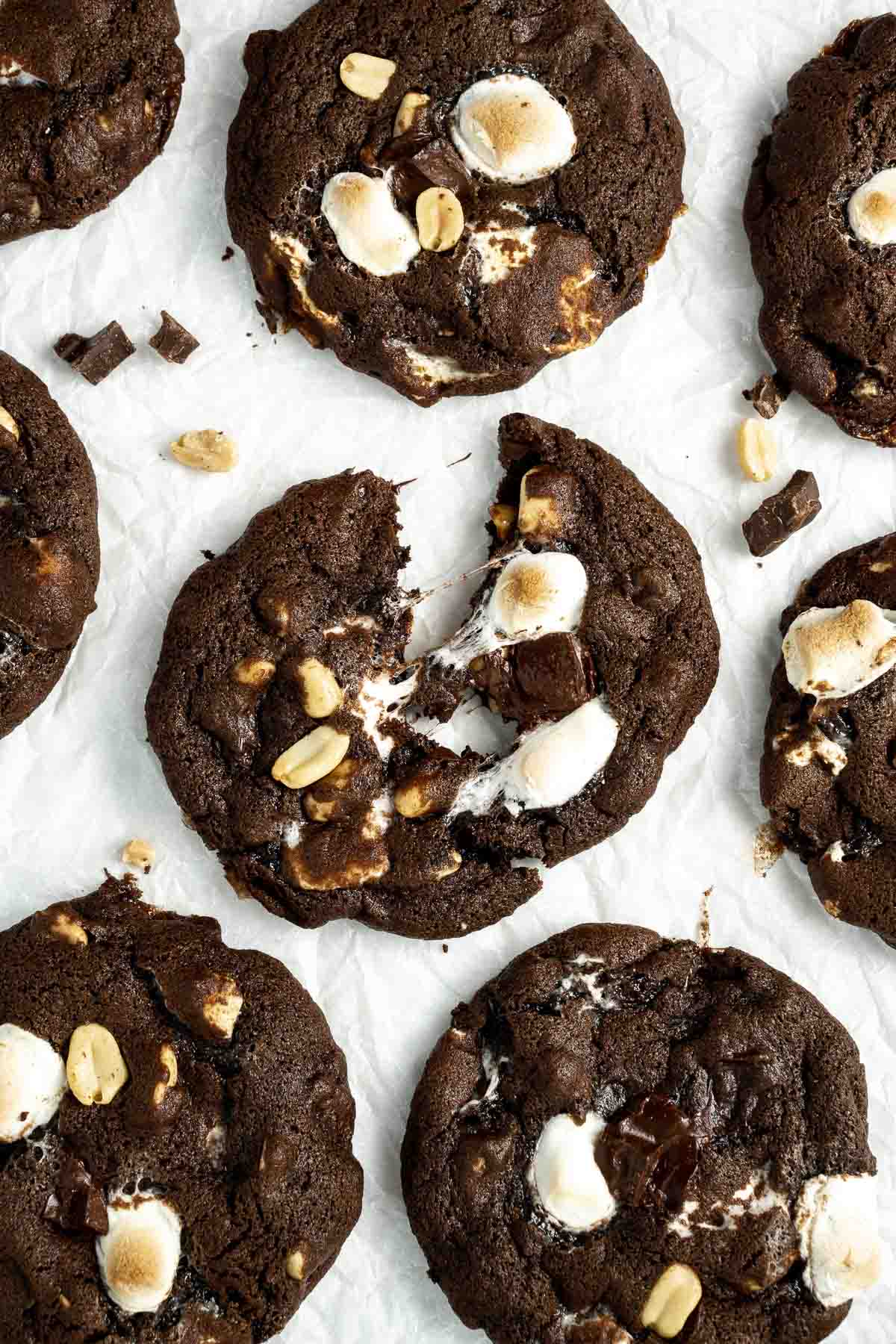 Rocky road cookies laid out on baking paper with gooey marshmallows and melted chocolate. 