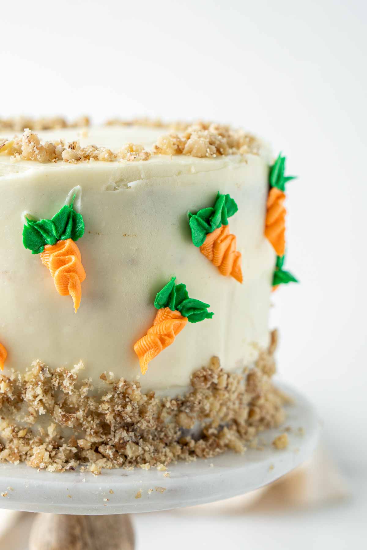 Close up of cute piped buttercream carrots on the cake.