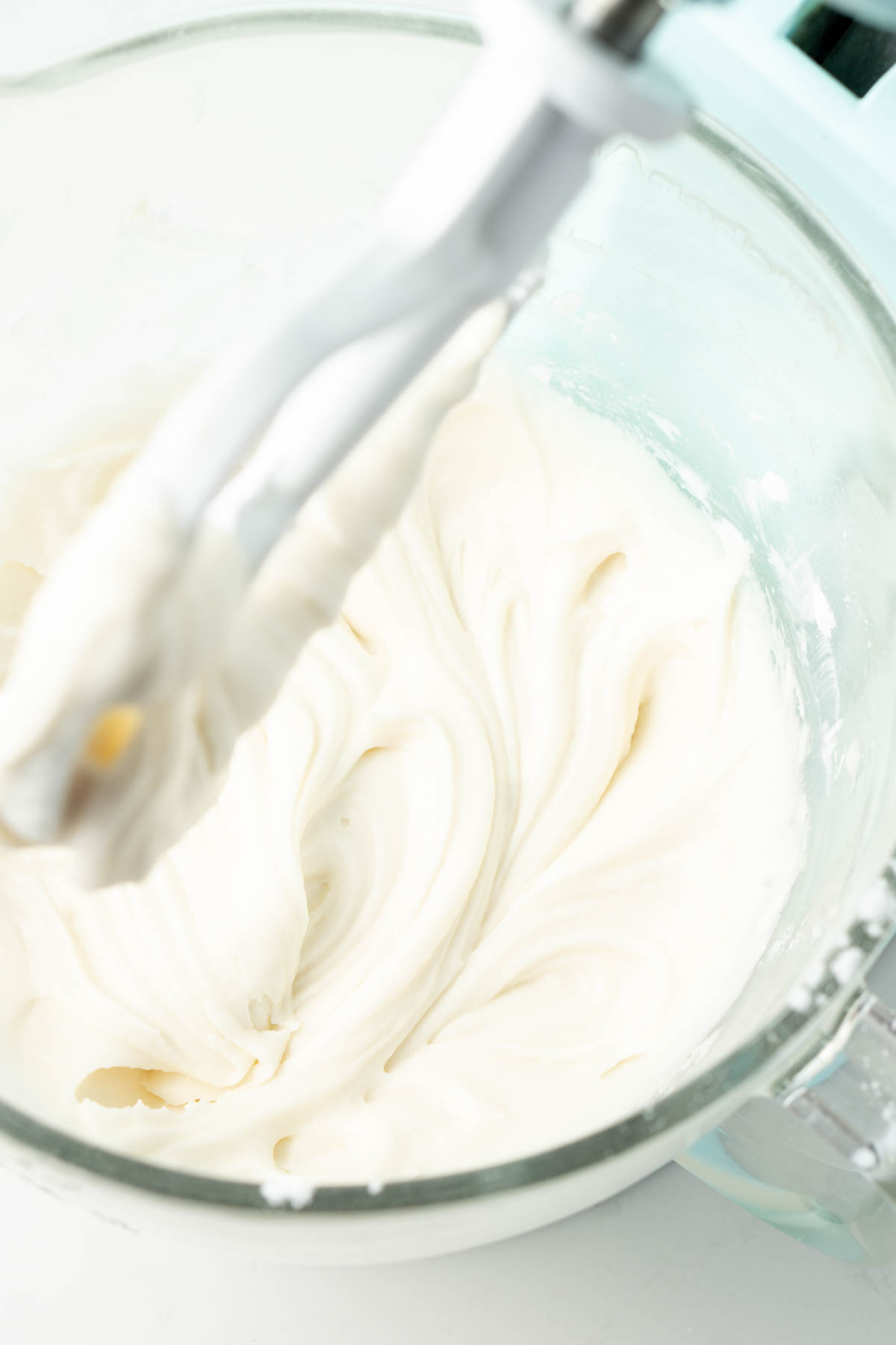 Close up of creamy frosting in the bowl of a stand mixer.
