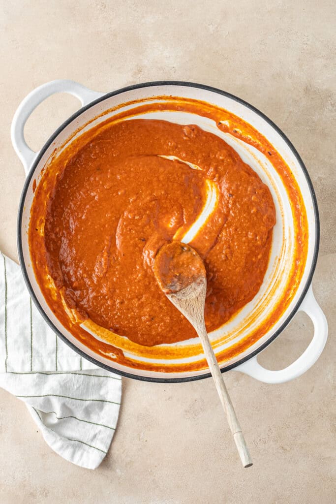 The creamy vodka sauce in the pot with a wooden spoon.