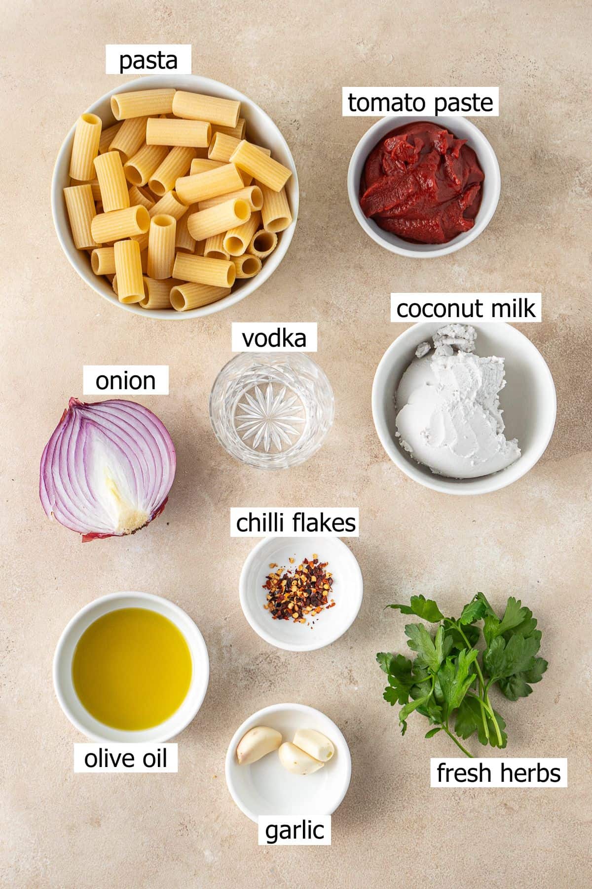 All ingredients needed to make vegan vodka pasta laid out in bowls.