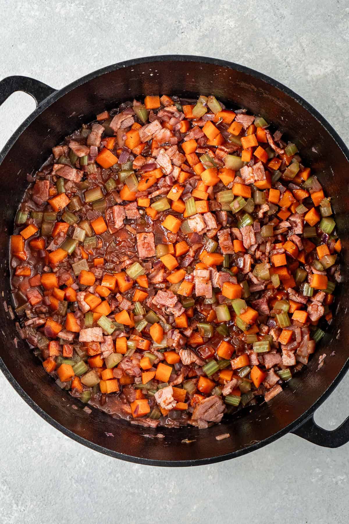 Cooking off the red wine with the vegetables in the pot.
