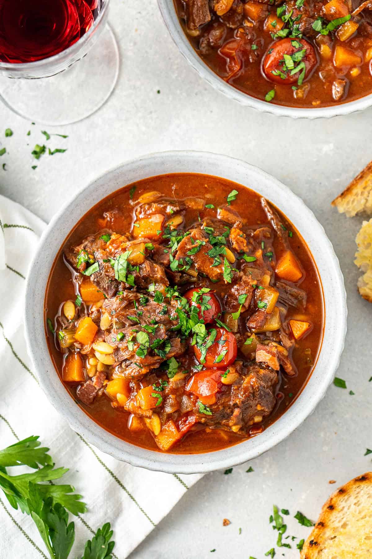 Beef minestrone soup in a bowl with fresh herbs.