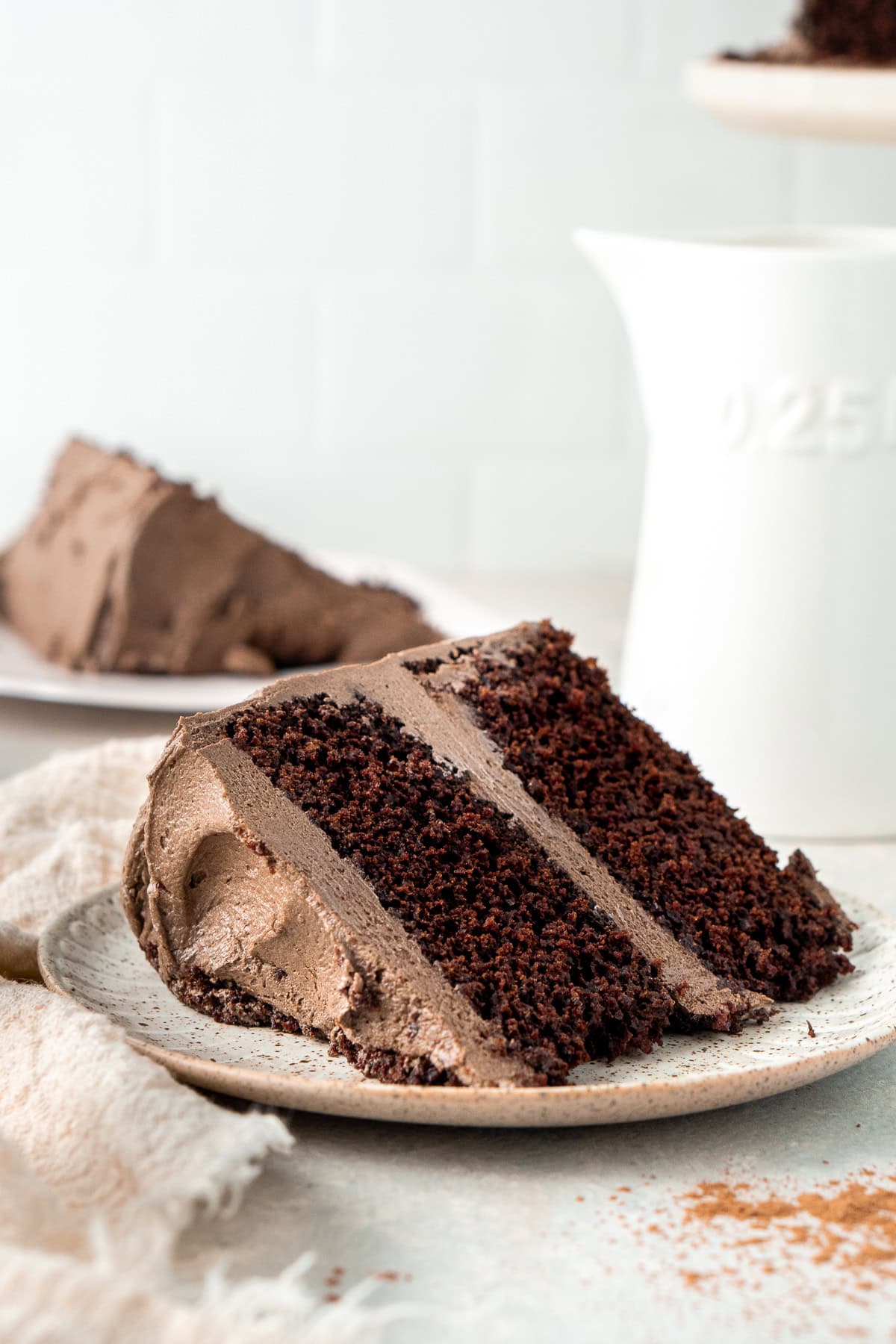 A slice of dairy free chocolate cake on a plate.