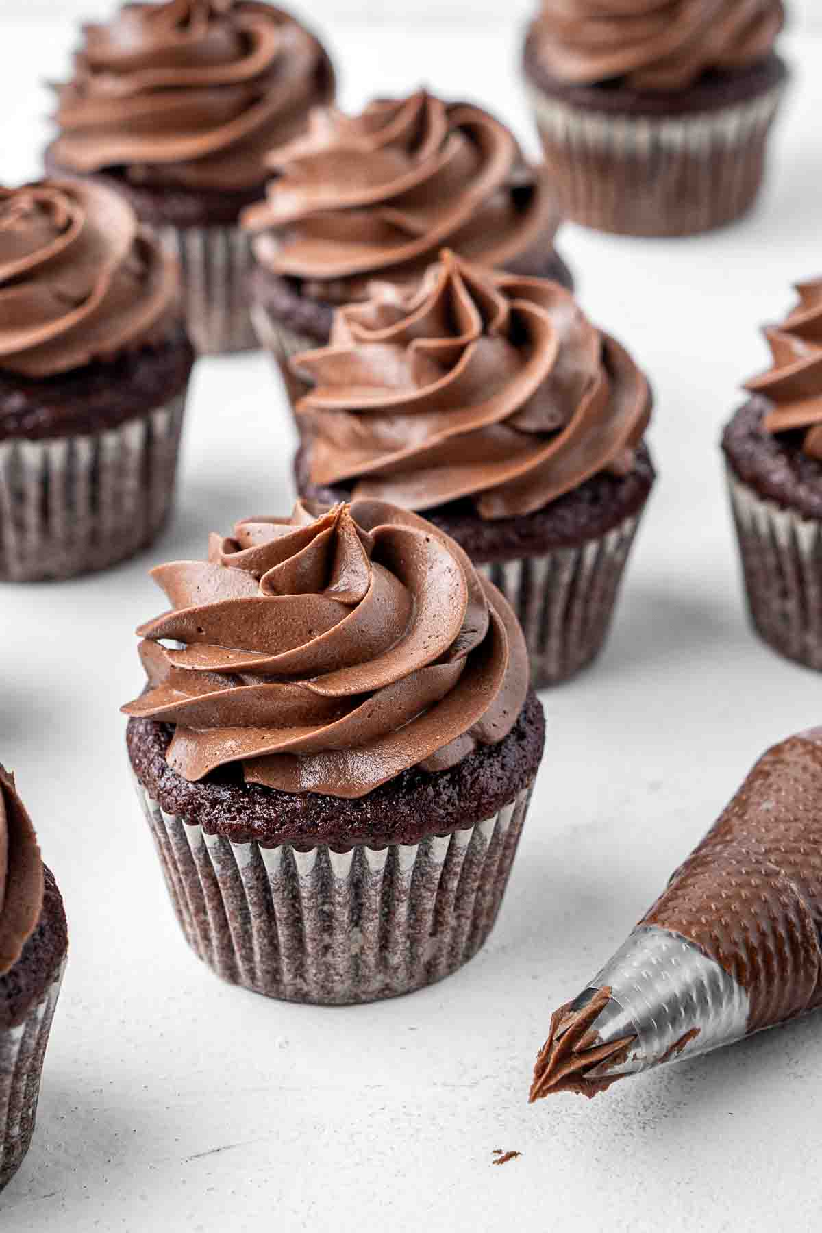 Vegan chocolate buttercream swirled on top of cupcakes.