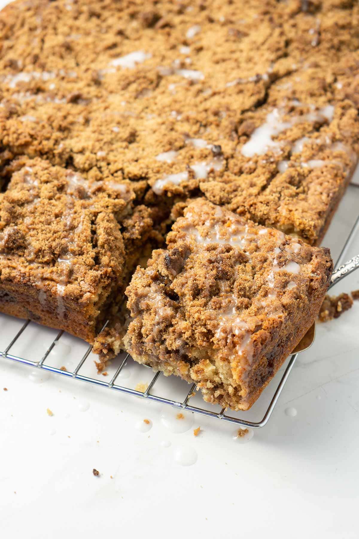 Coffee cake being cut into squares and served.