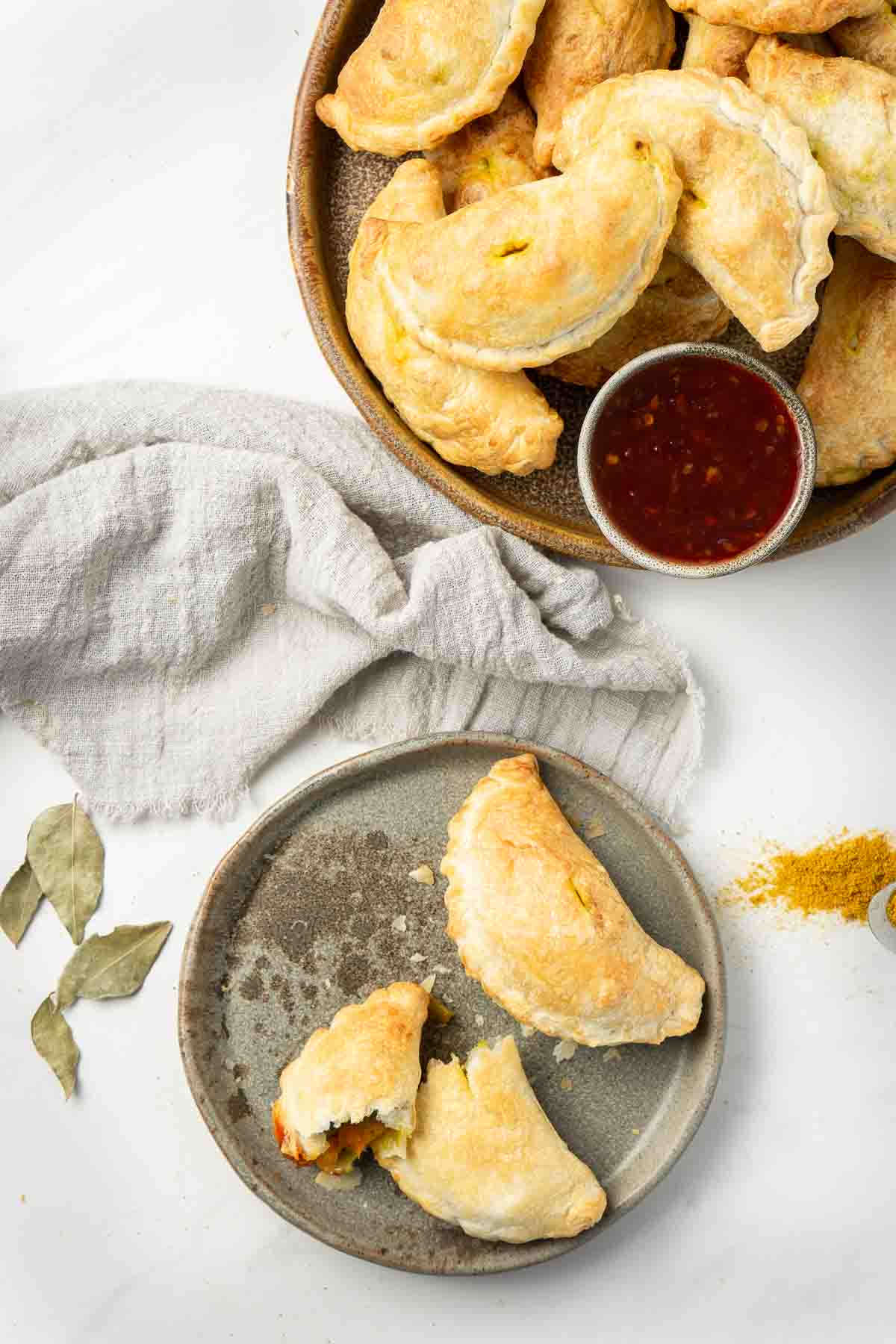 Vegetarian curry puffs being served on plates.