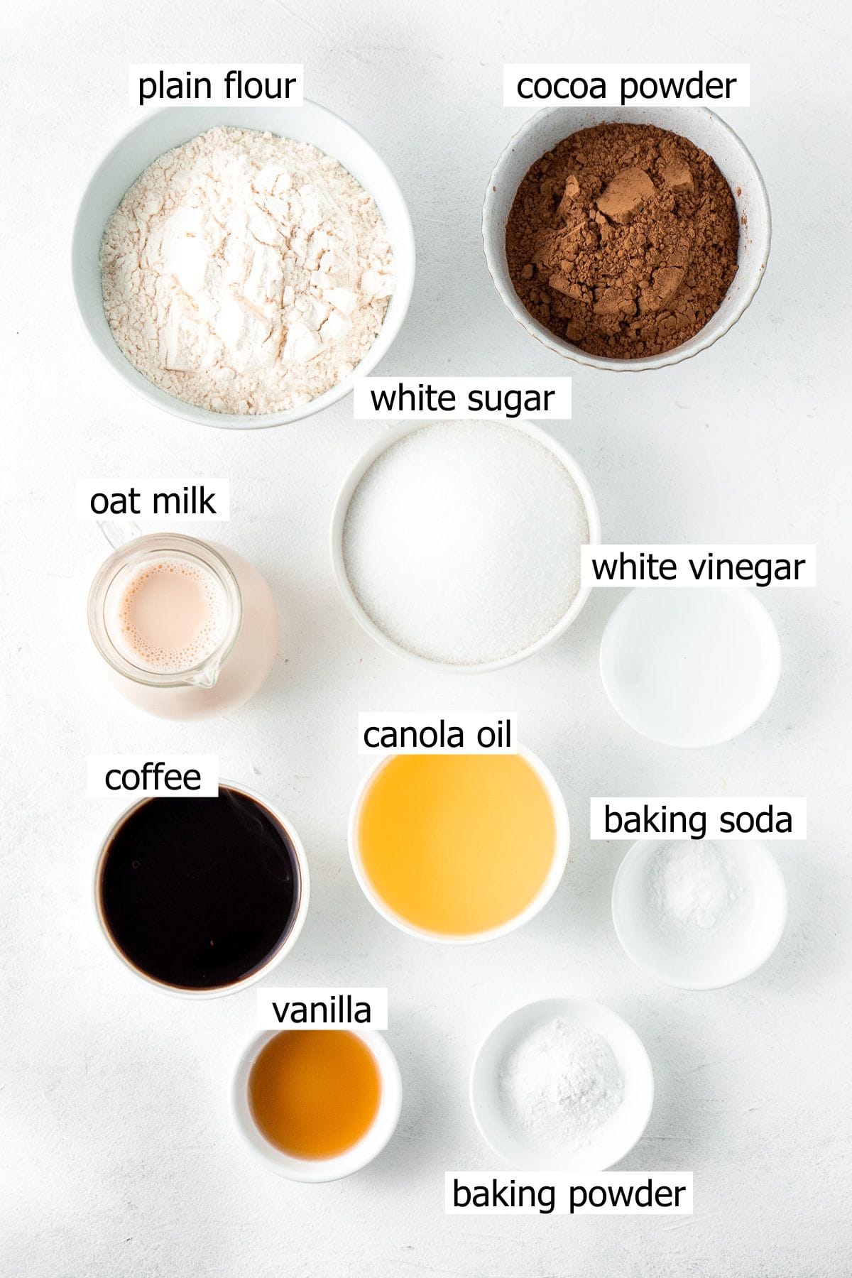 All ingredients needed to make dairy free chocolate cake laid out in small bowls.