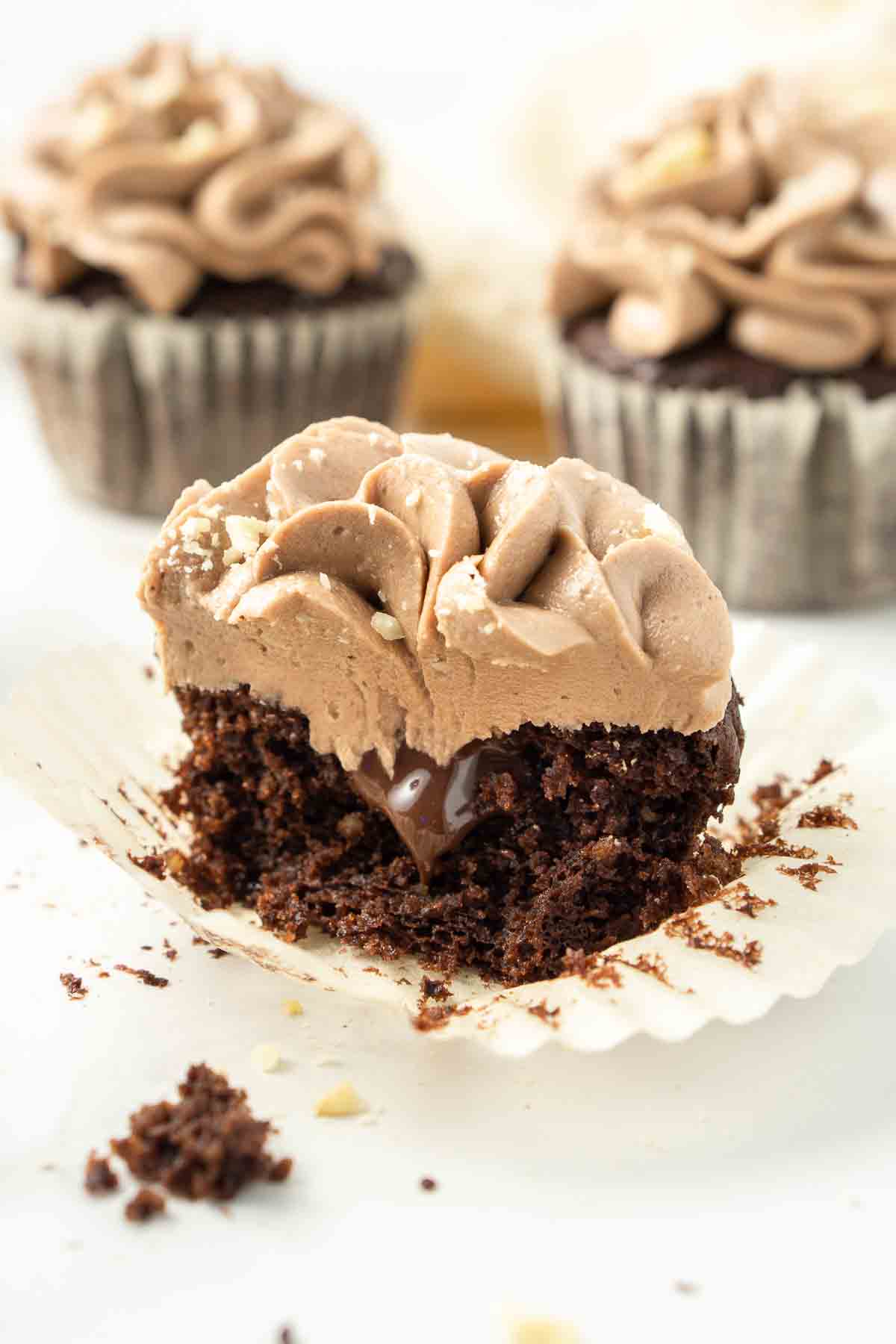 Chocolate hazelnut cupcake cut in half with chocolate spread in the middle oozing out. 