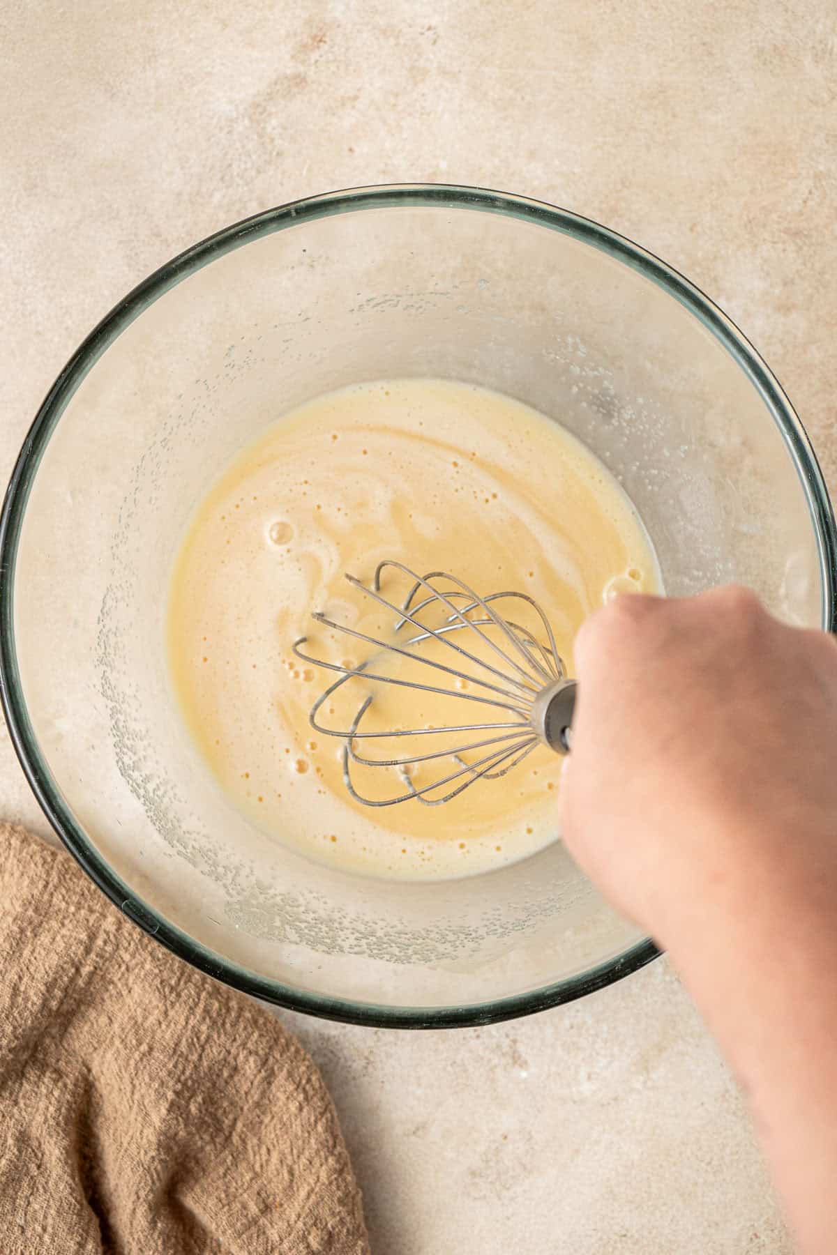 Whisking together the wet ingredients in a bowl.