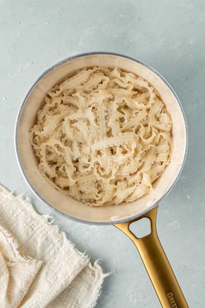 The cooked noodles in a small saucepan.