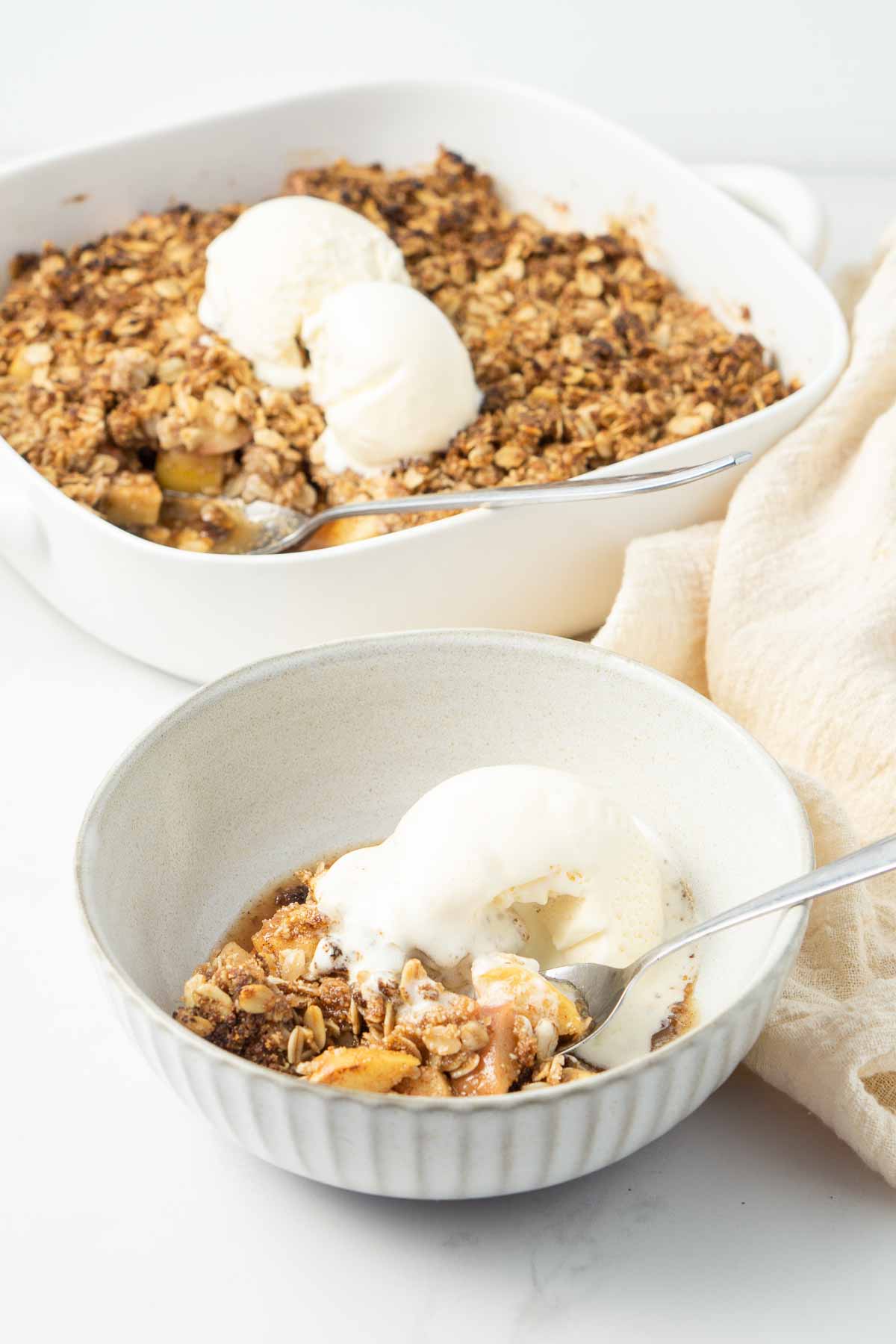 Apple crumble and ice cream in a bowl.
