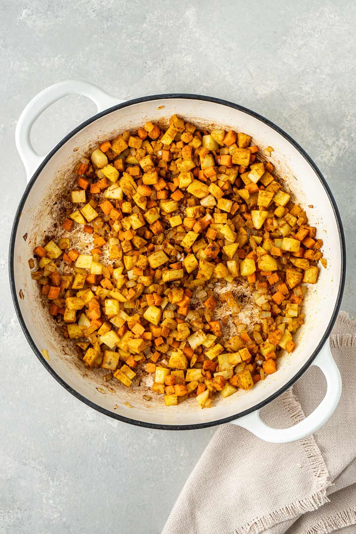 Cooking the potato and spices in the frying pan.