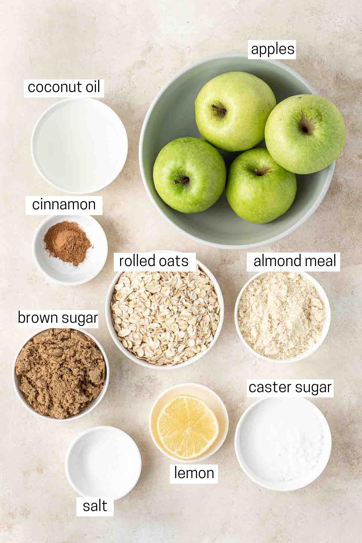All ingredients needed to make apple crumble laid out in bowls.