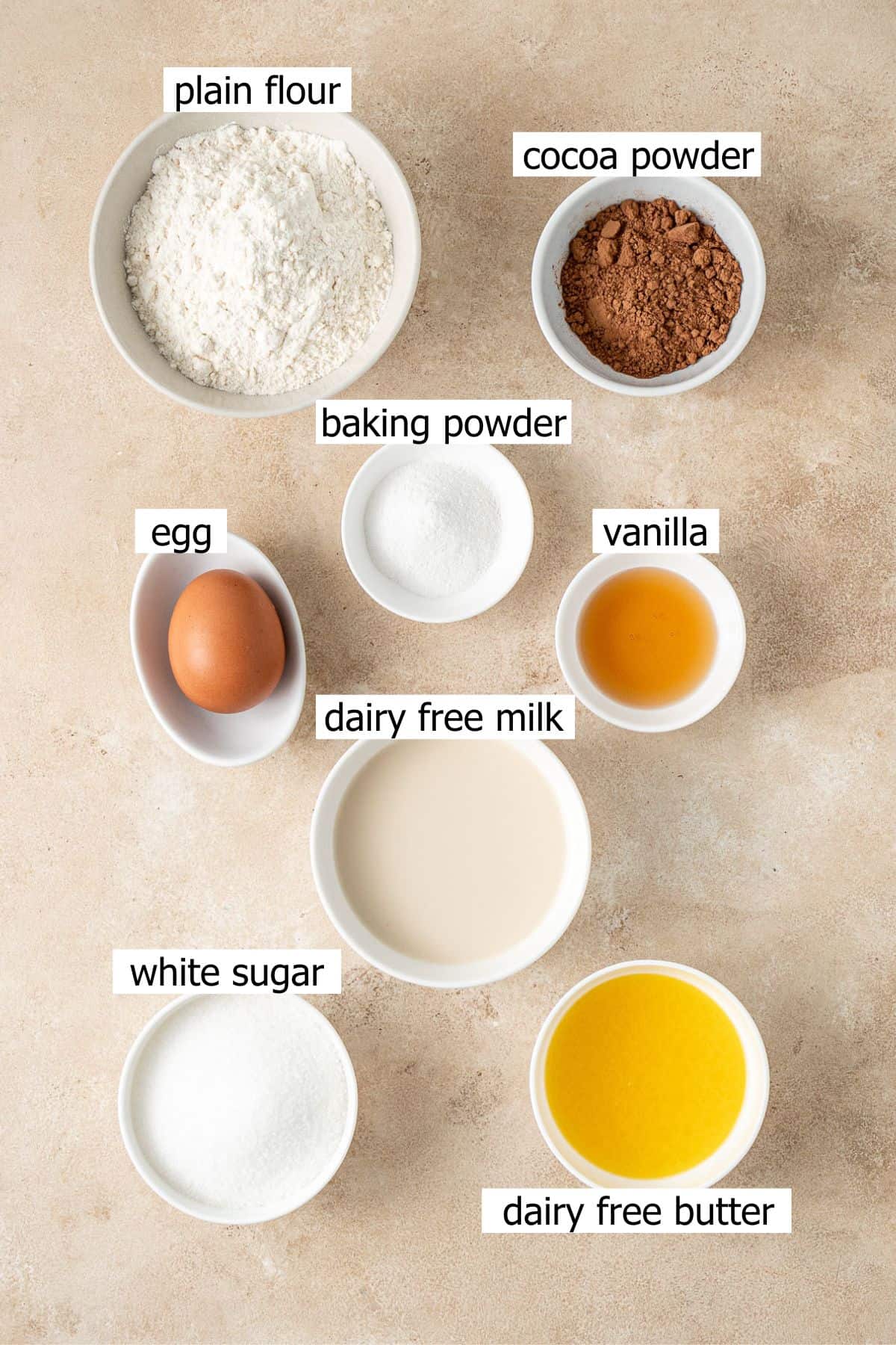 All ingredients needed to make chocolate self saucing pudding laid out in bowls.
