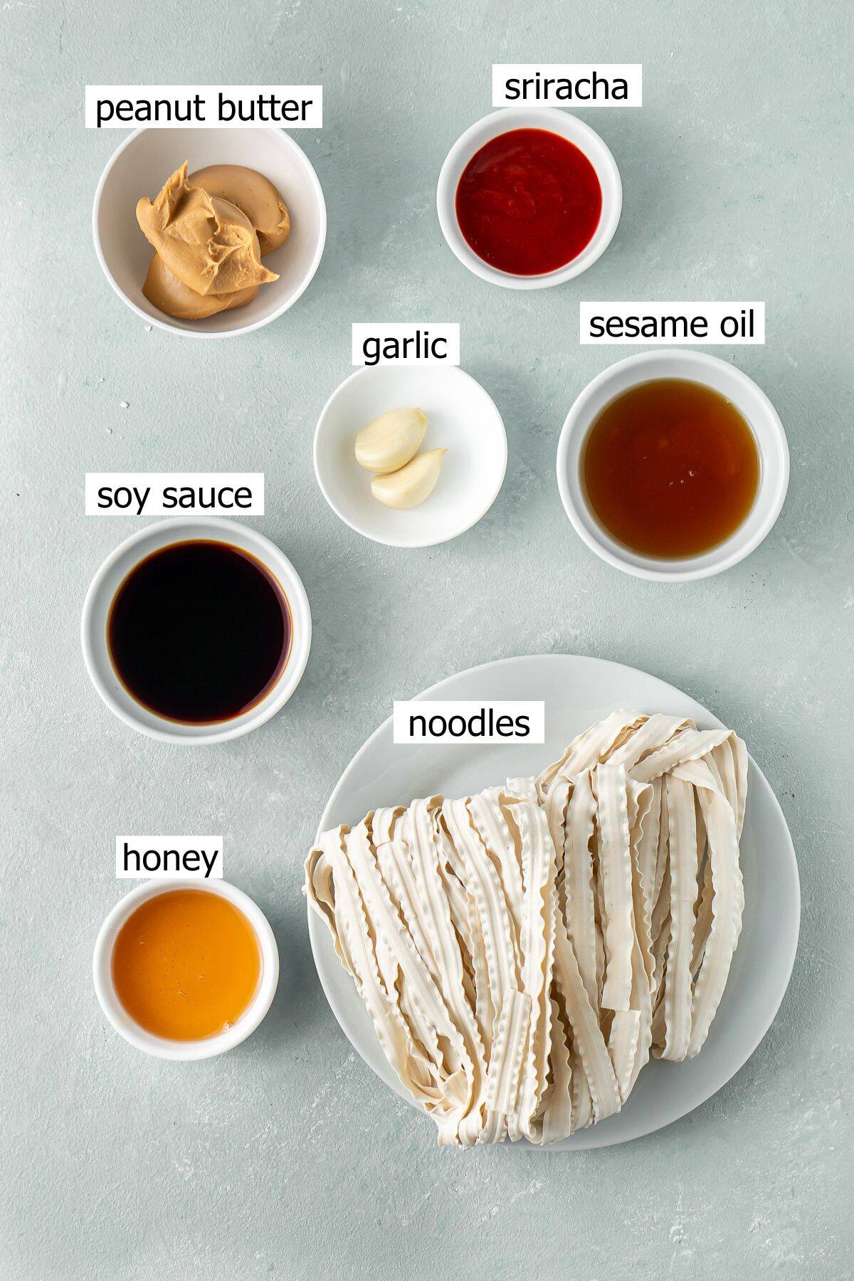 All ingredients for peanut butter noodles, laid out in small bowls.