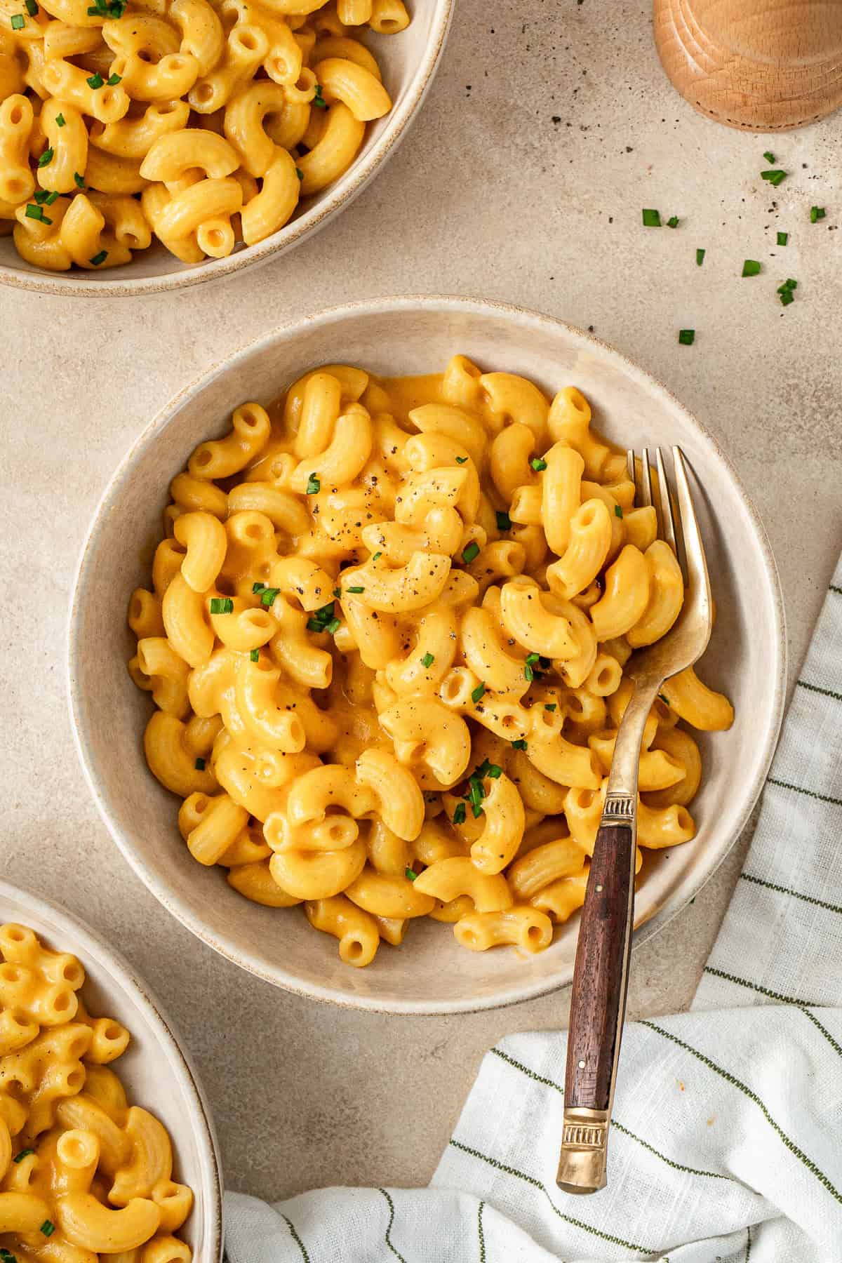 A bowl of vegan sweet potato mac and cheese with a fork.