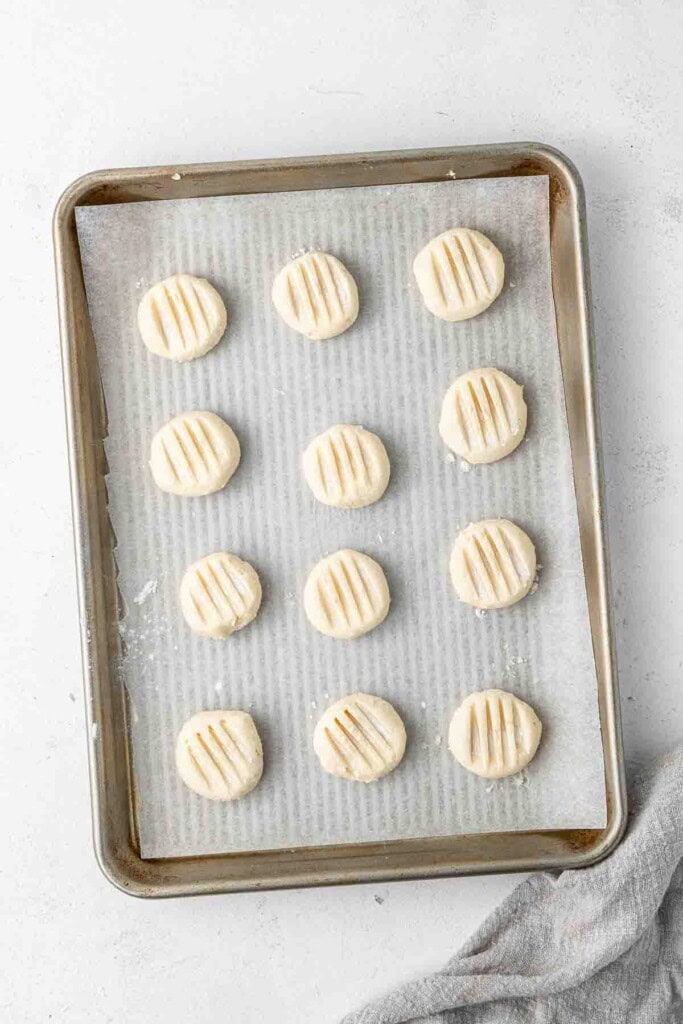 Cookie dough pressed down on a baking tray.