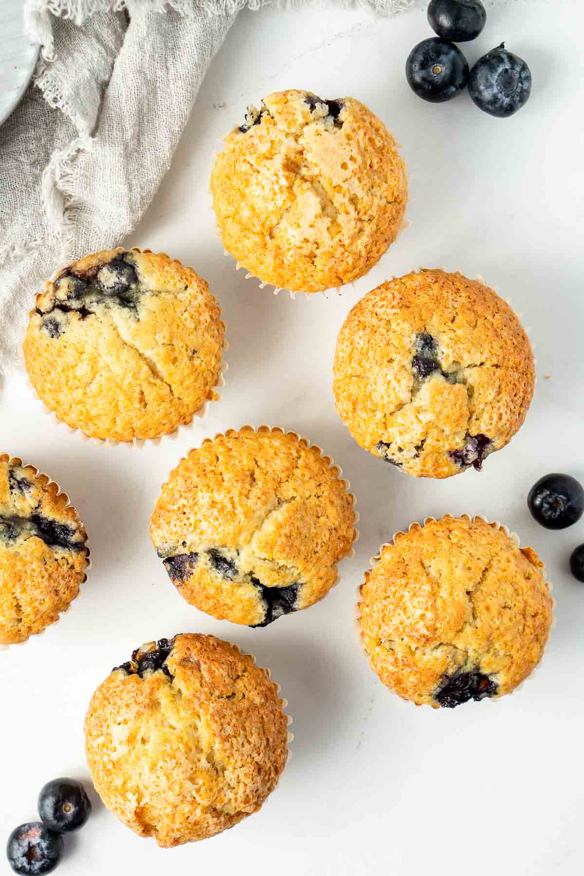 Blueberry muffins on a white table from above.