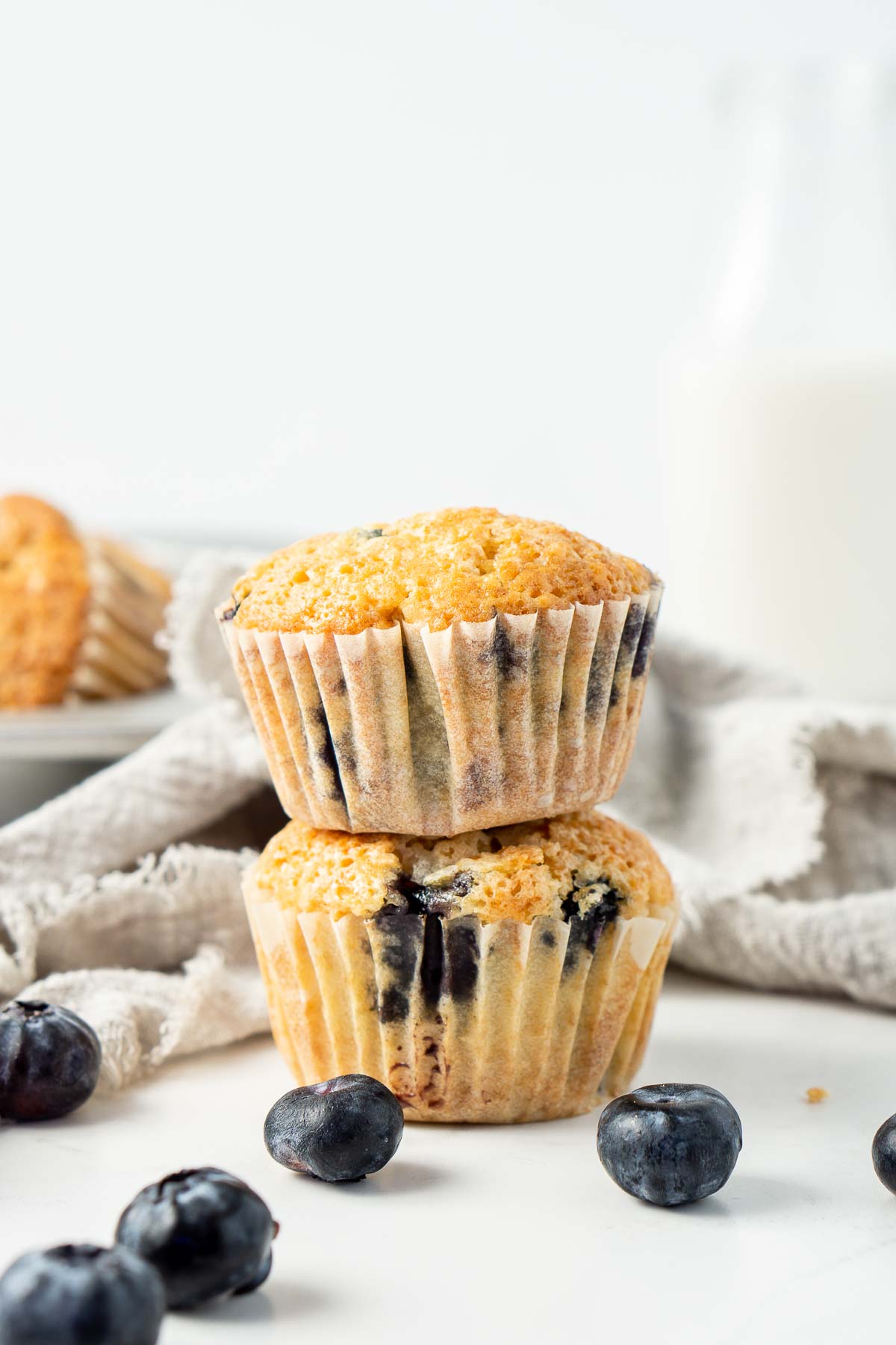 Two dairy free blueberry muffins stacked on top of each other.