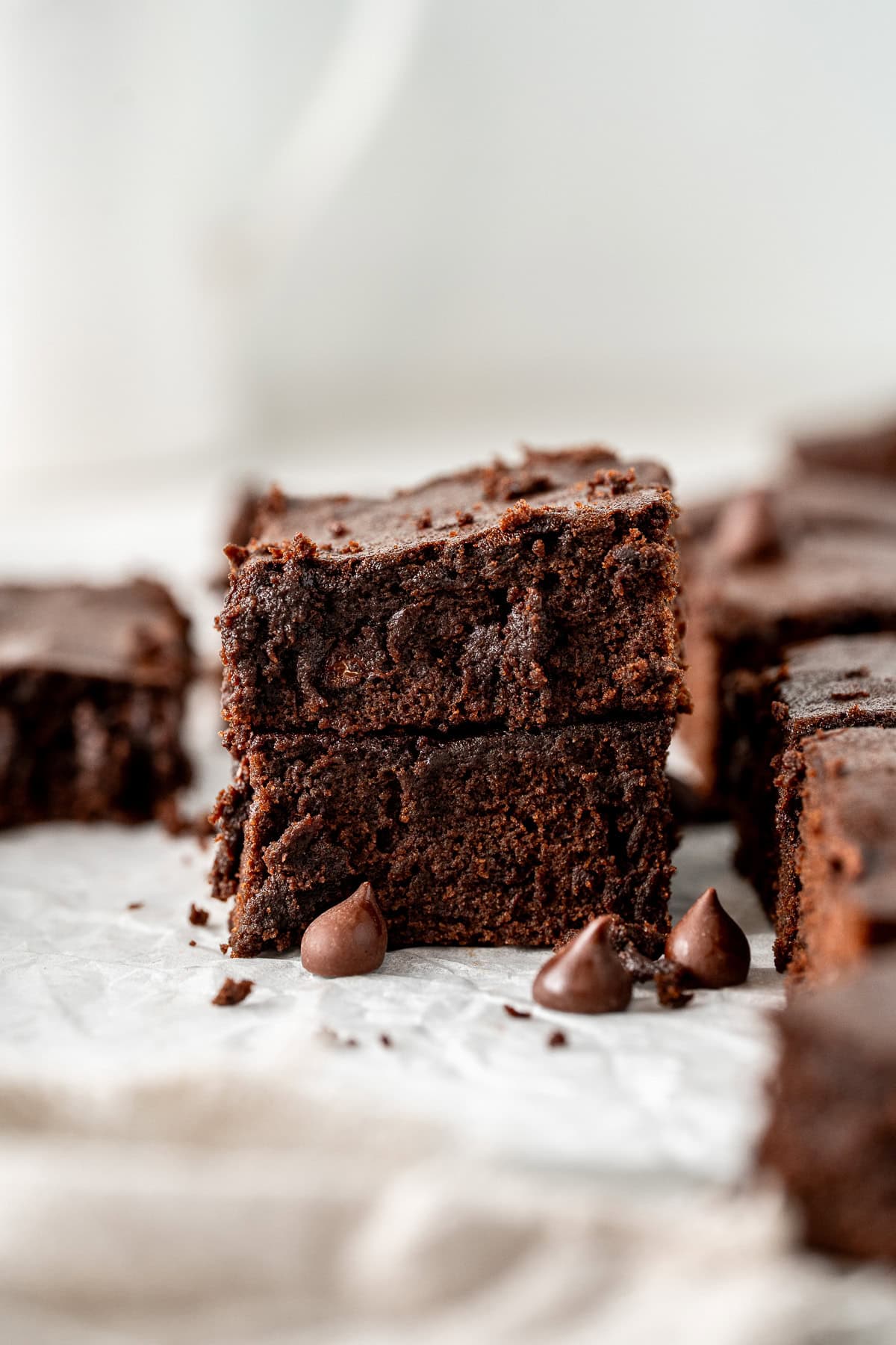 Two dairy free brownies stacked on top of each other with extra chocolate chips.