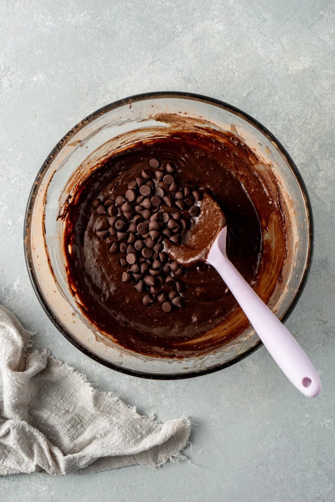 Mixing together the brownie batter in a glass bowl.