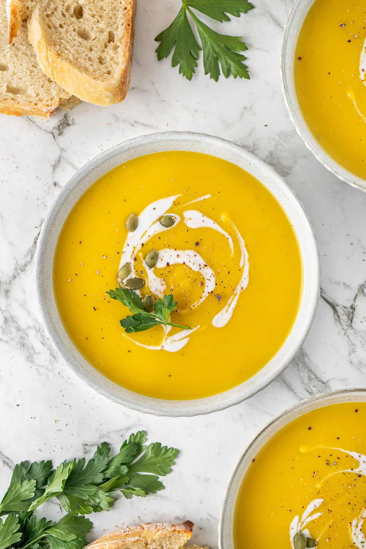 The dairy free pumpkin soup served into bowls.