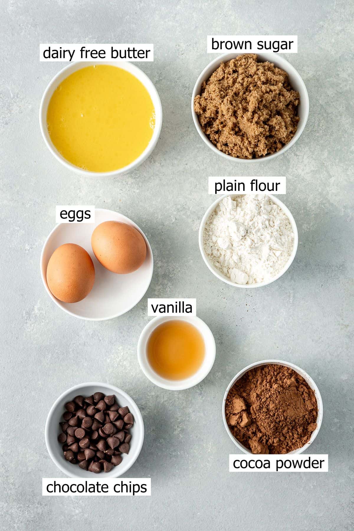 All ingredients needed to make dairy free chocolate brownies laid out in small bowls.