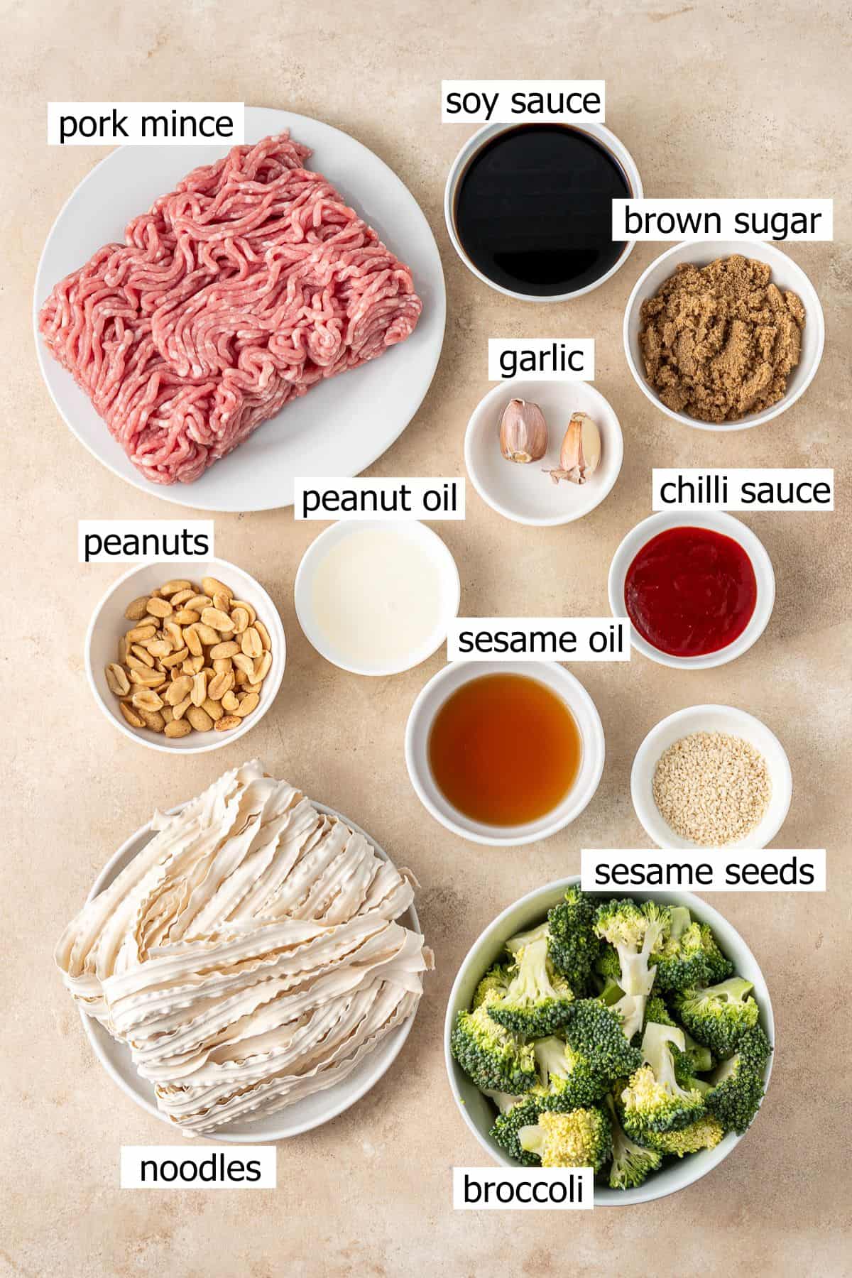 All ingredients needed to make spicy pork and peanut noodles laid out in bowls.