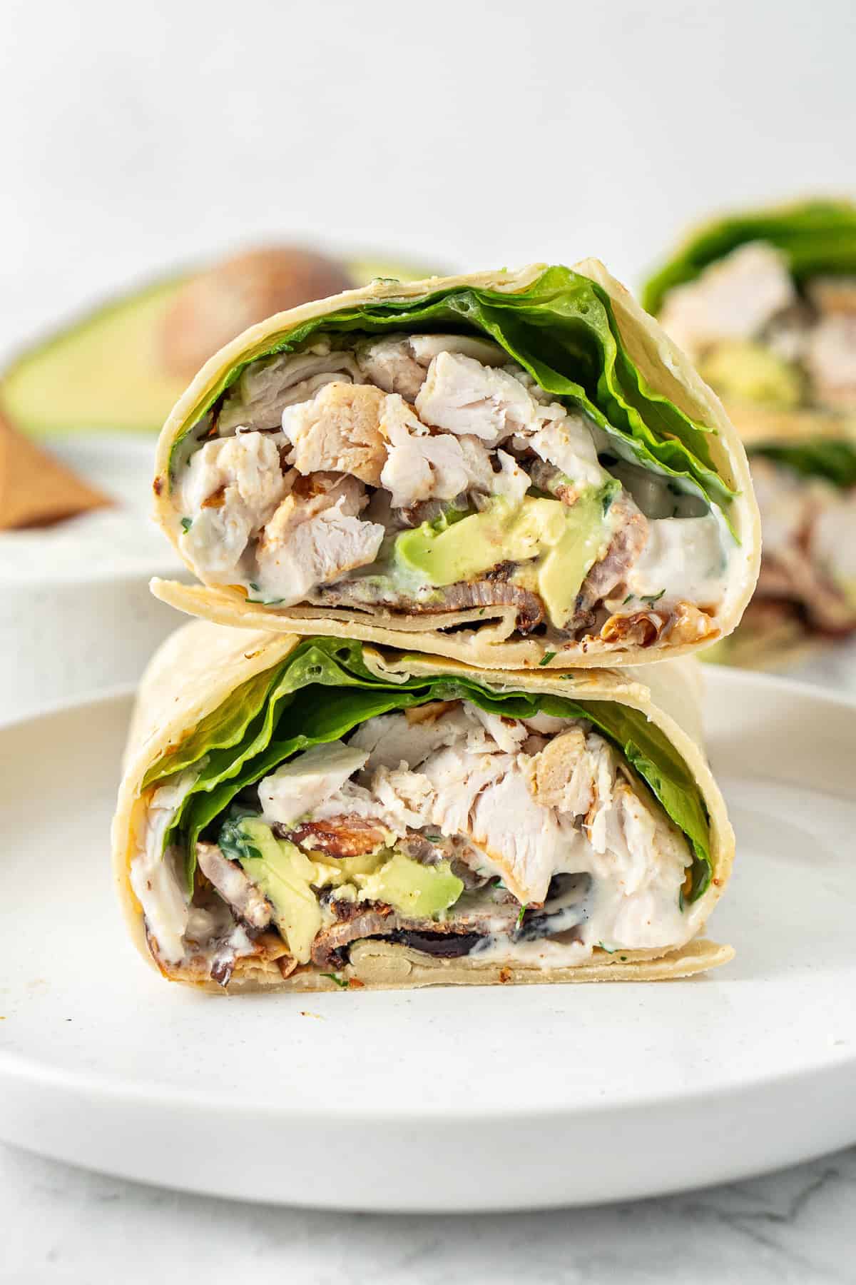 A chicken bacon ranch wrap cut in half and stacked on top of each other.