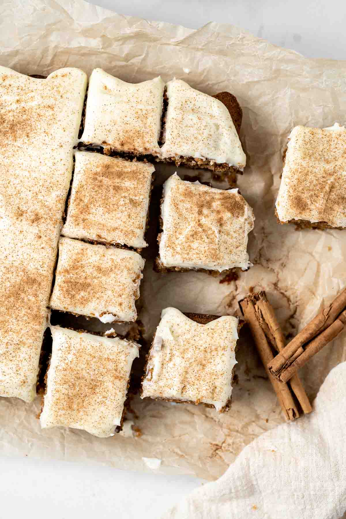 Overhead photo of gingerbread snack cake cut into squares with cream cheese frosting.