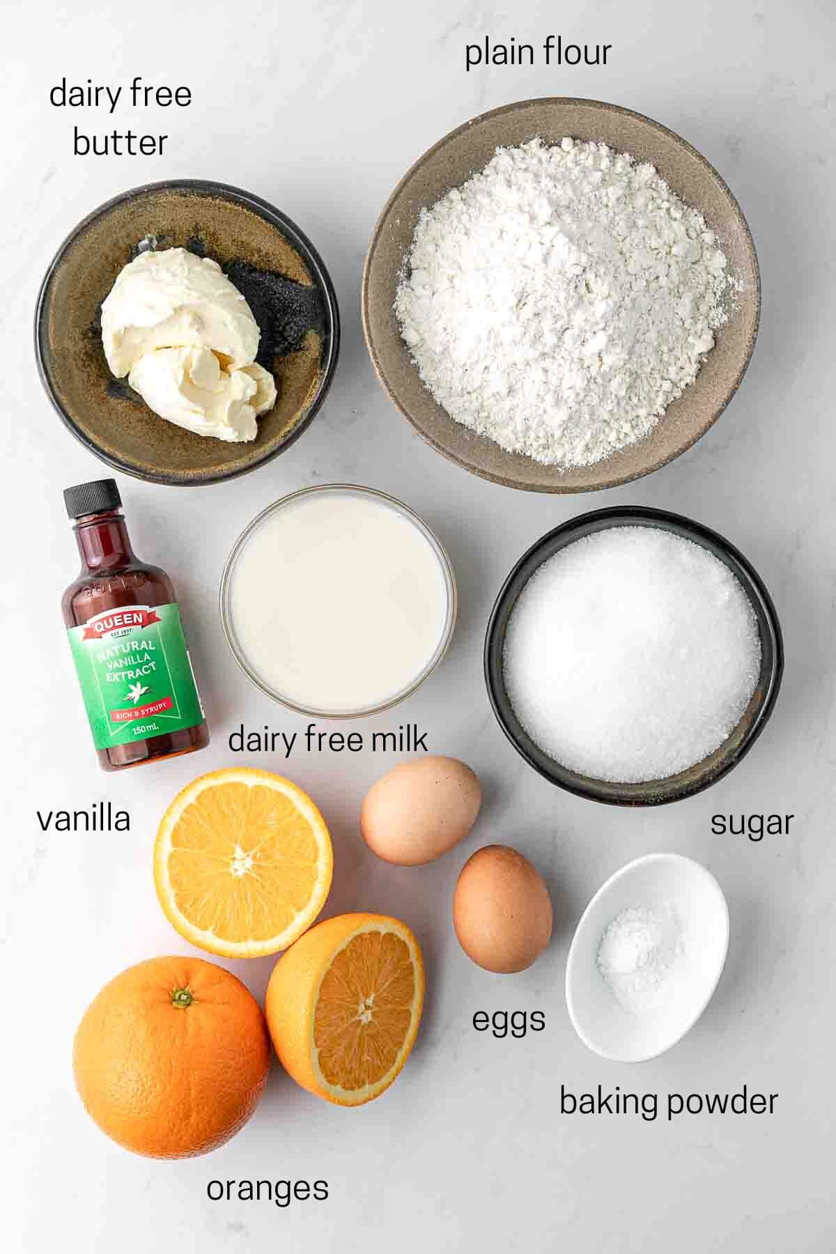 All ingredients needed for orange pound cake laid out in small bowls.