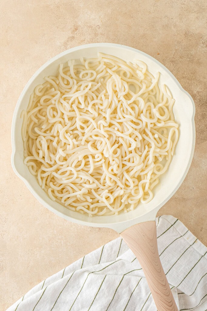 The udon noodles in the frying pan.