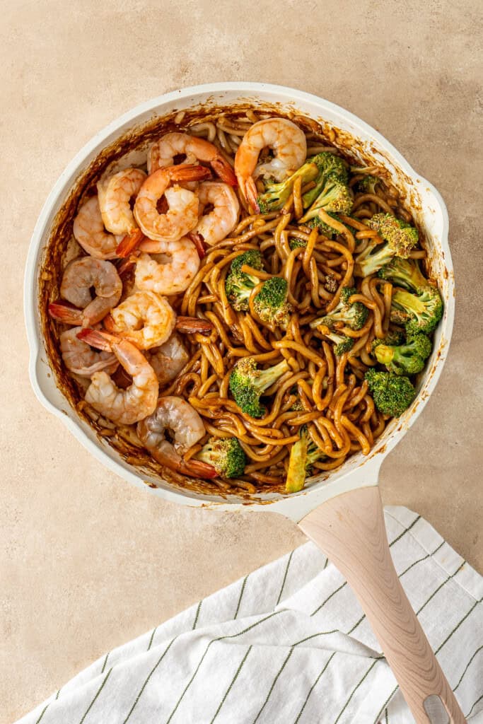 Cooking the prawns in the pan with the noodles.