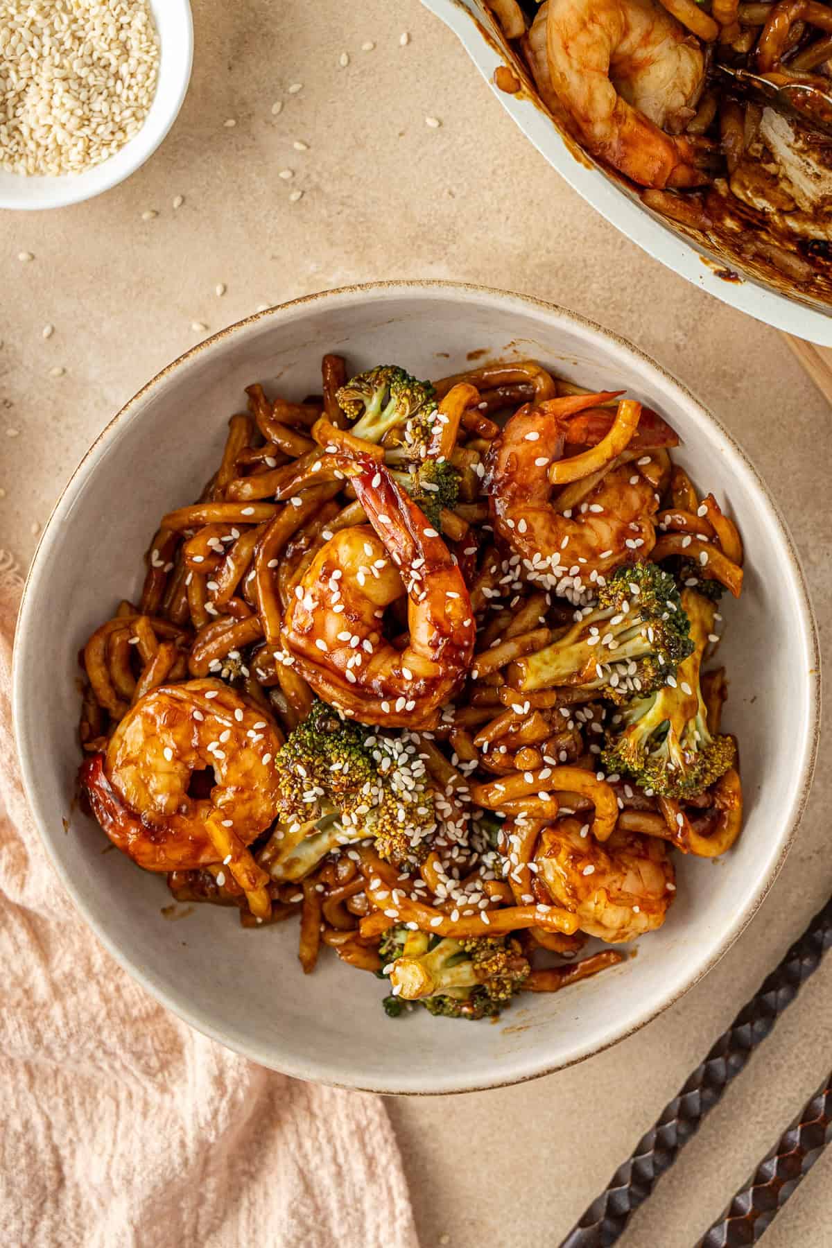 Garlic prawn noodles in a bowl topped with sesame seeds.