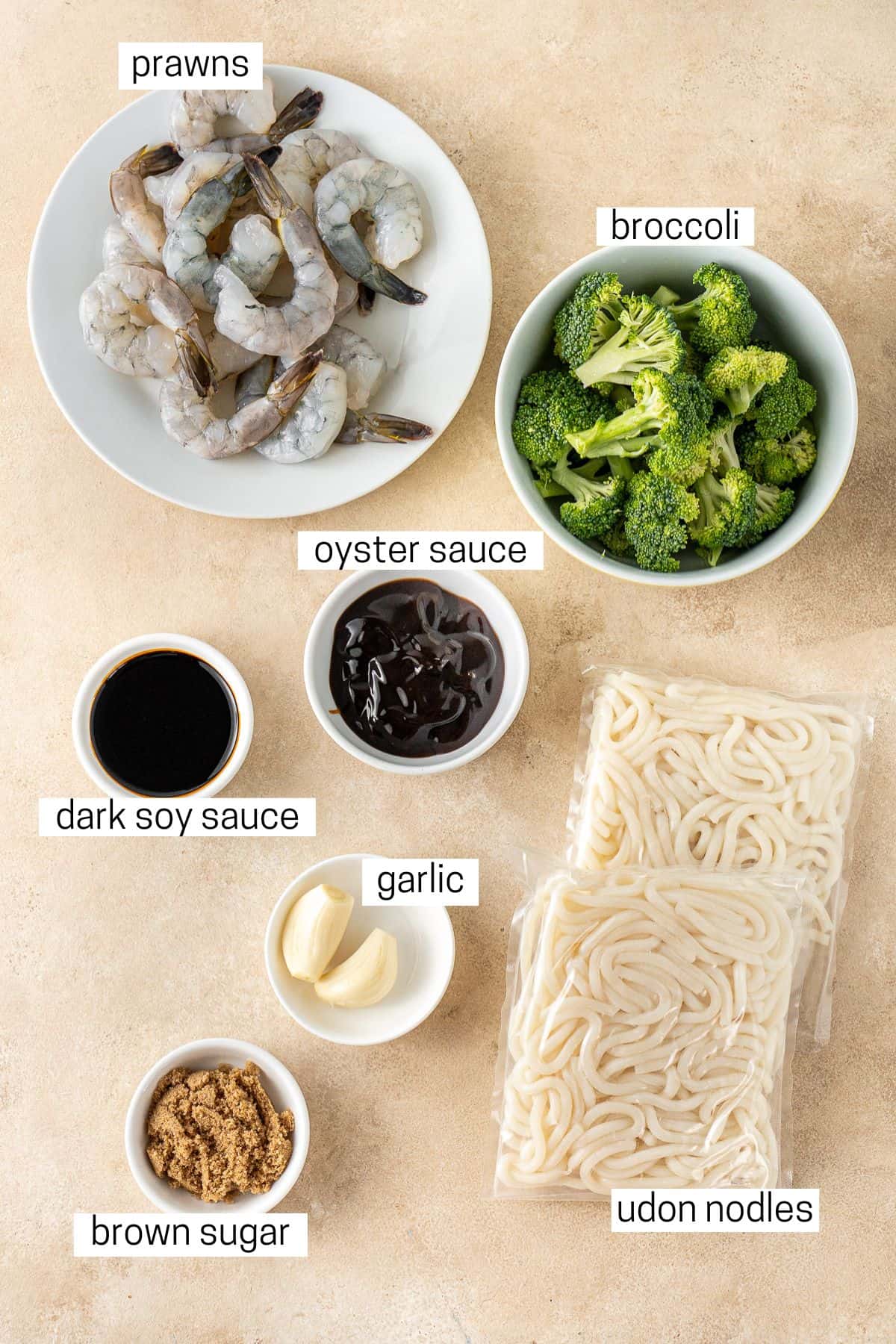 All ingredients needed to make garlic prawn noodles laid out in bowls.