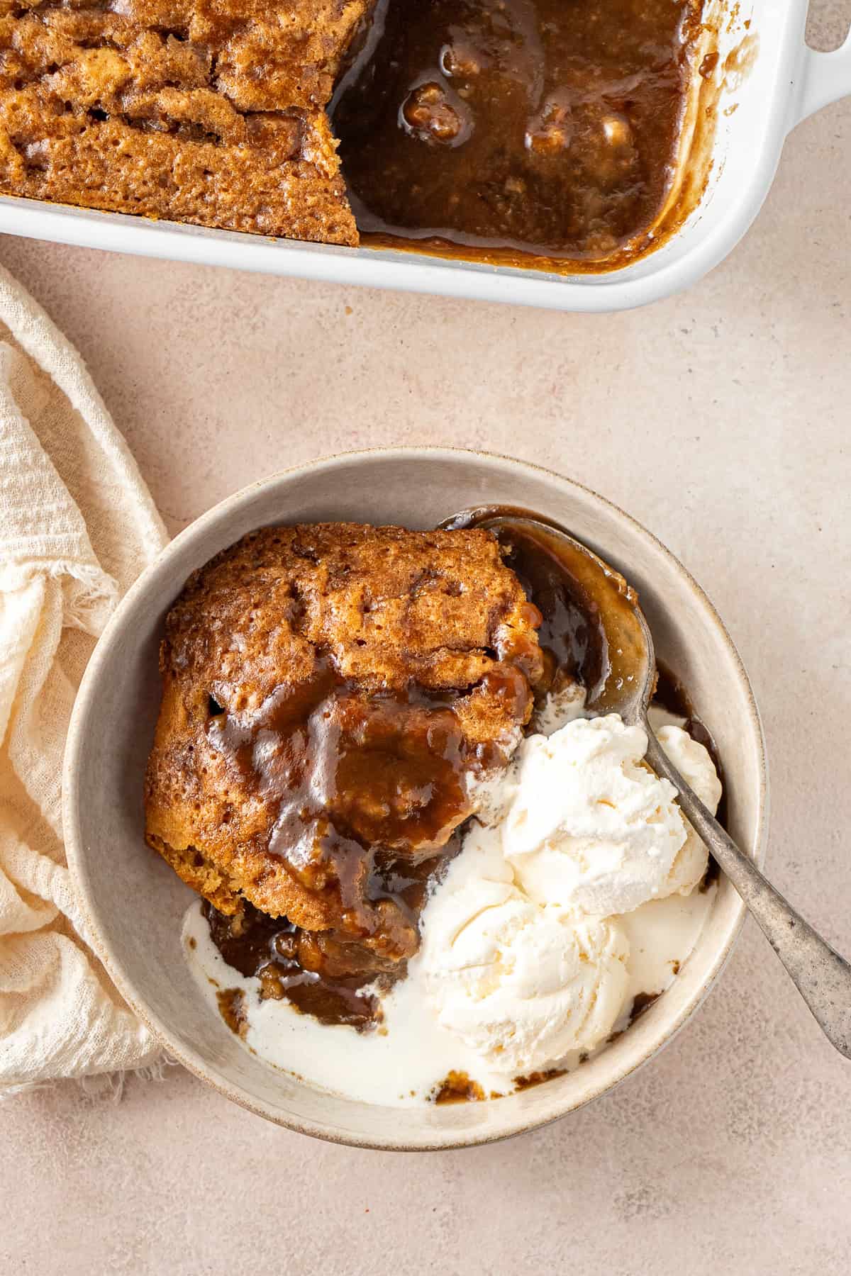 The self saucing butterscotch pudding served into a bowl with icecream.
